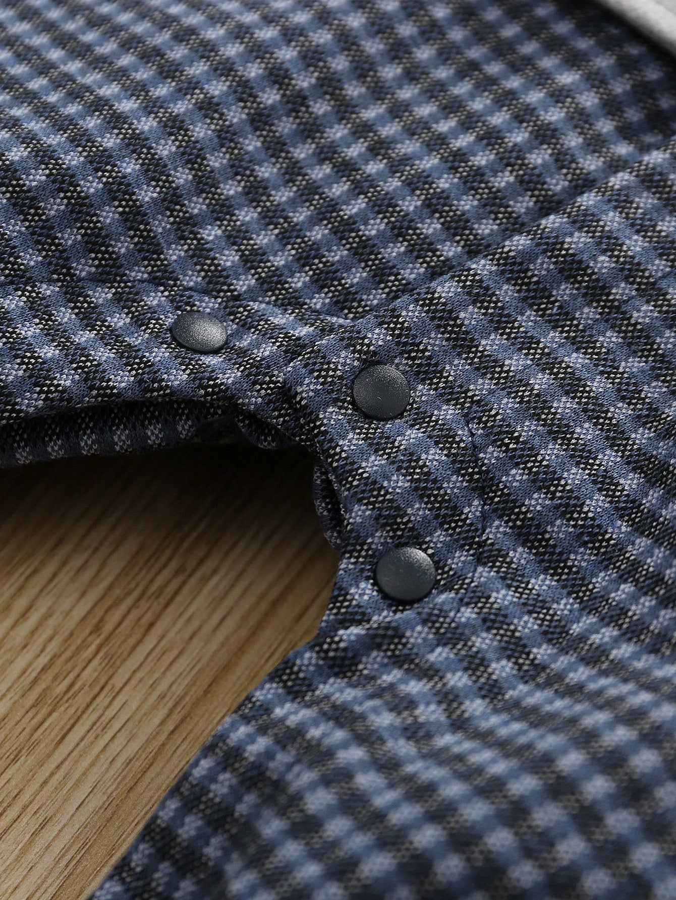 Prenda gris pelele para bebe detalle del estampado de cuadros y broches inferiores