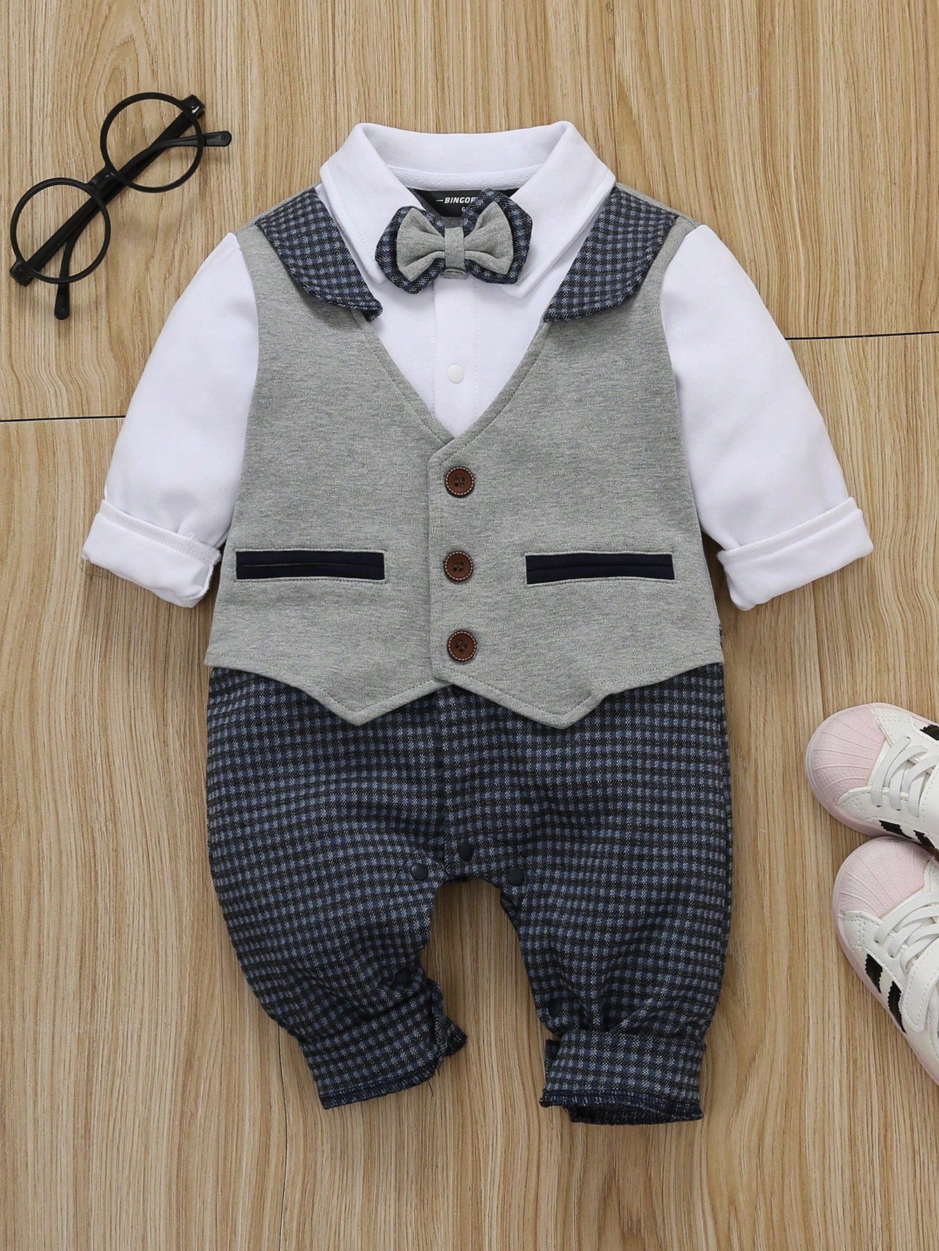 Prenda gris pelele para bebe vista frontal con pajarita y cuadros azul marino
