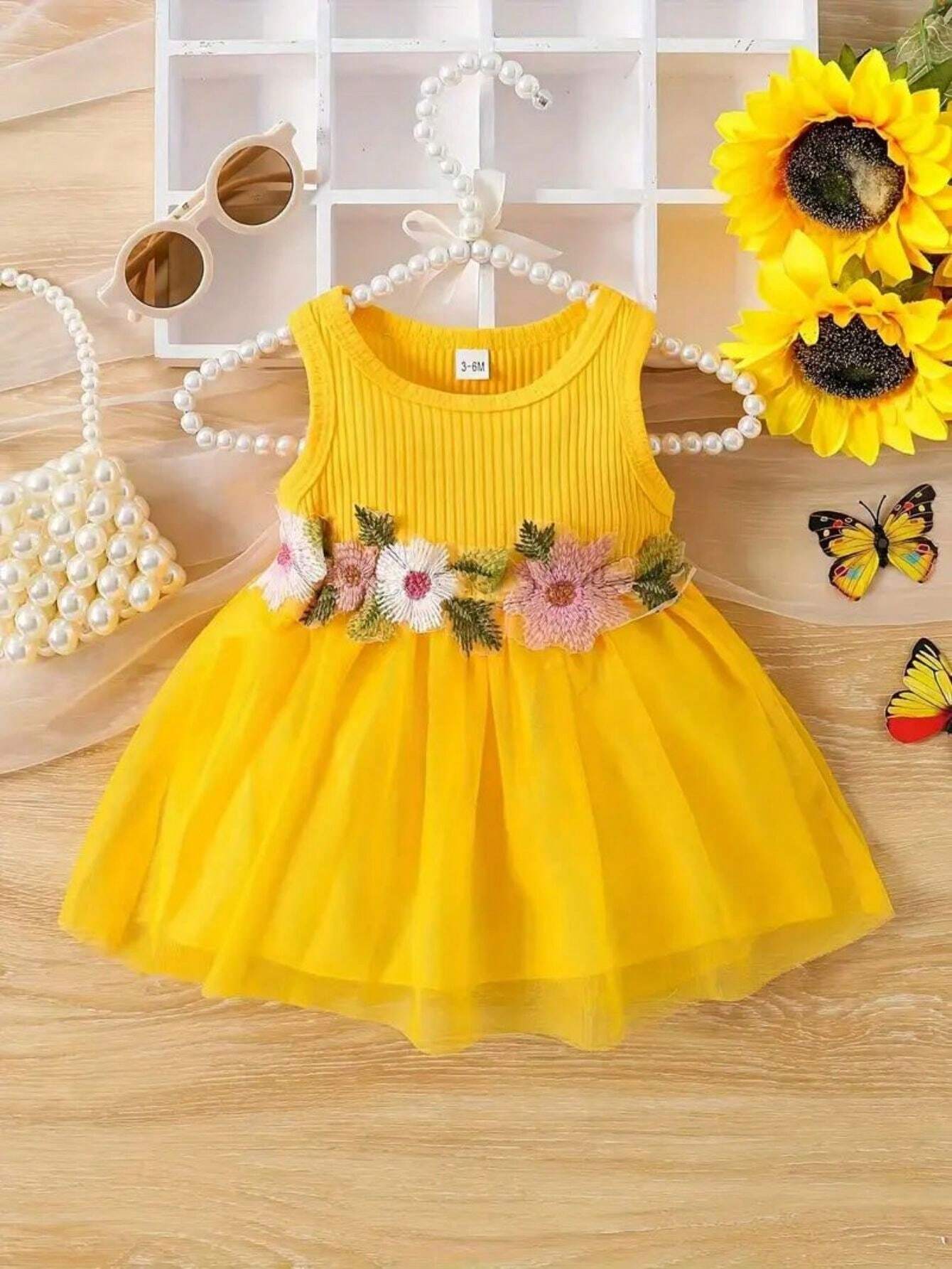 Prenda amarilla vestido para bebe con flores bordadas en la cintura vista frontal
