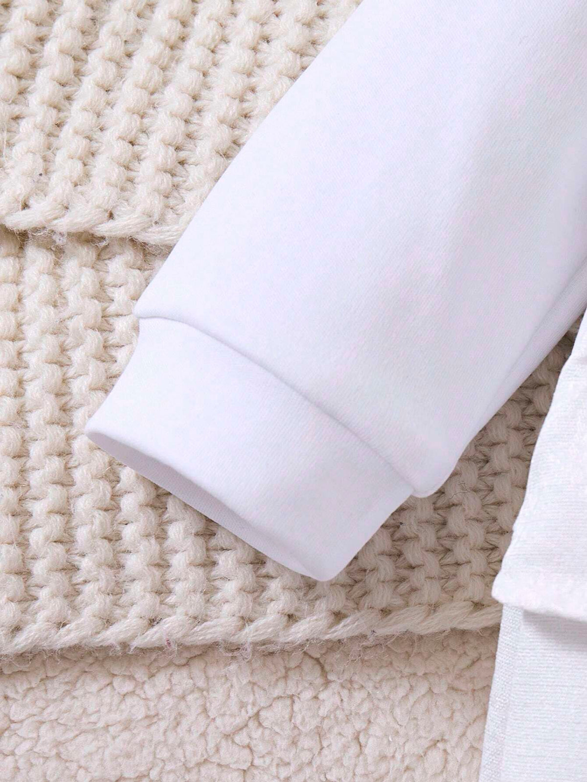 Prenda blanca enterizo para bebe detalle de manga larga y puño