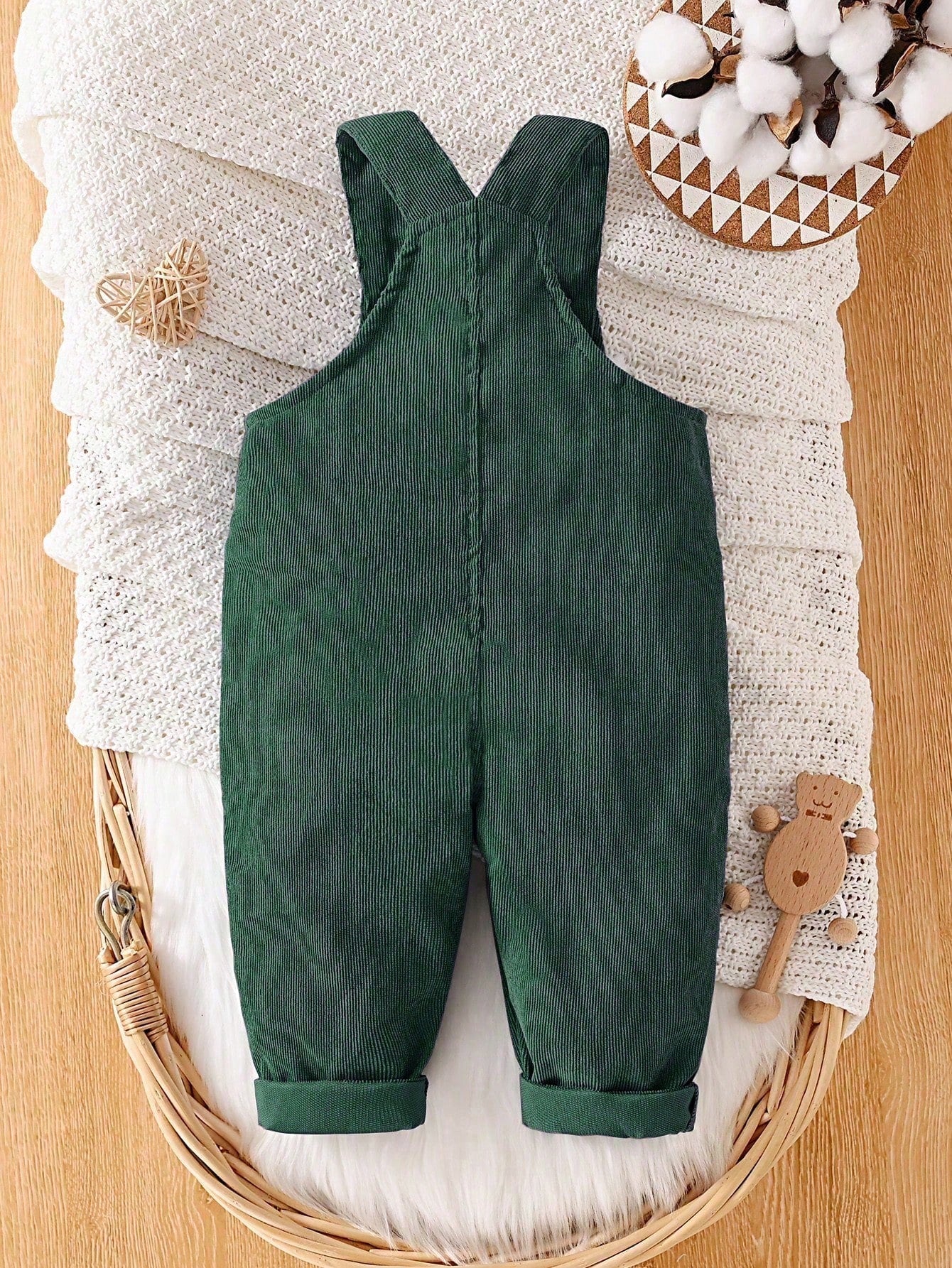Prenda verde oscuro overol para bebe vista trasera con tirantes cruzados