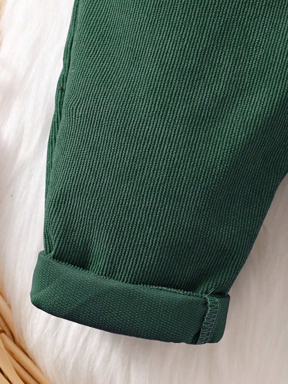 Prenda verde oscuro overol para bebe detalle de la tela de pana y bajos doblados