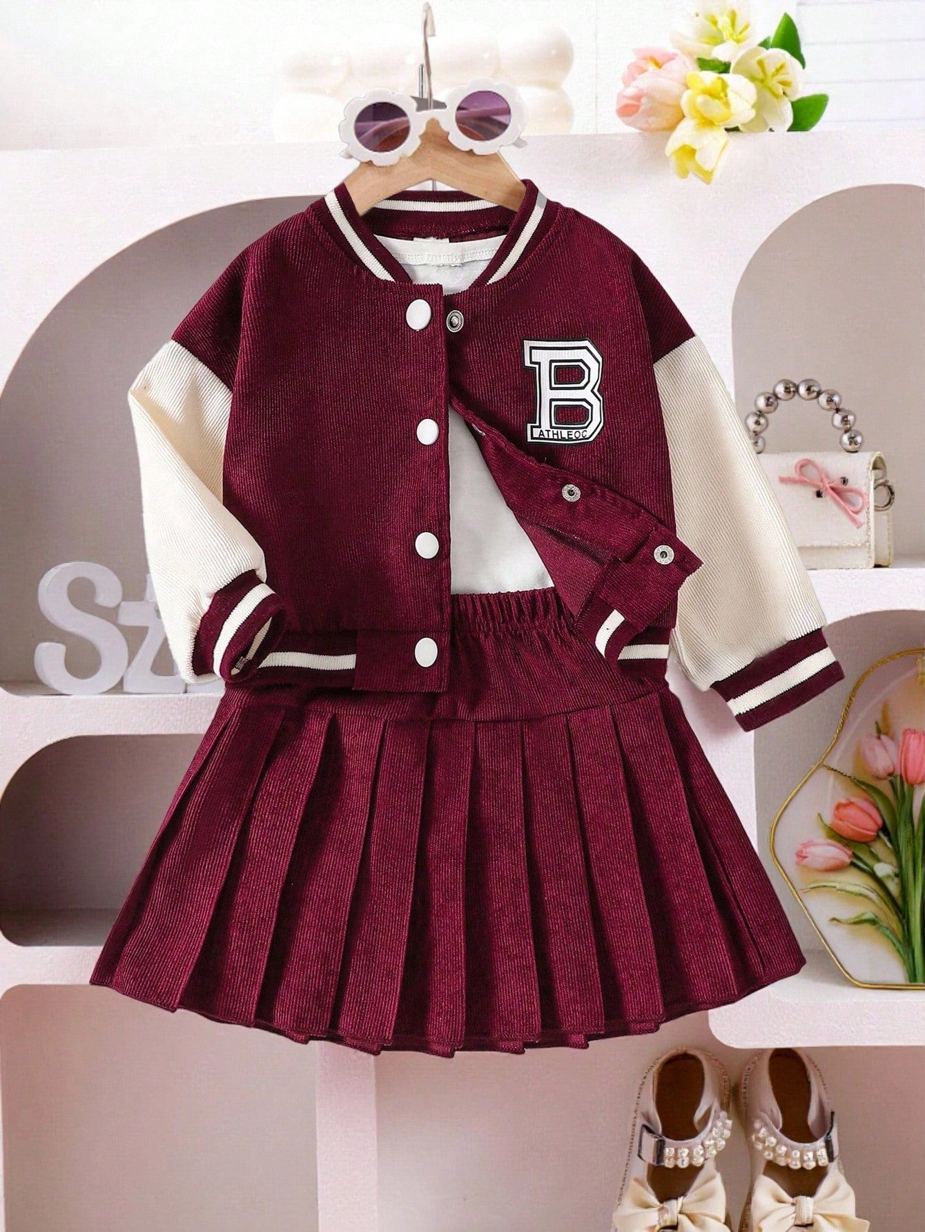 Prenda burdeos conjunto para bebe con chaqueta universitaria y falda plisada vista frontal