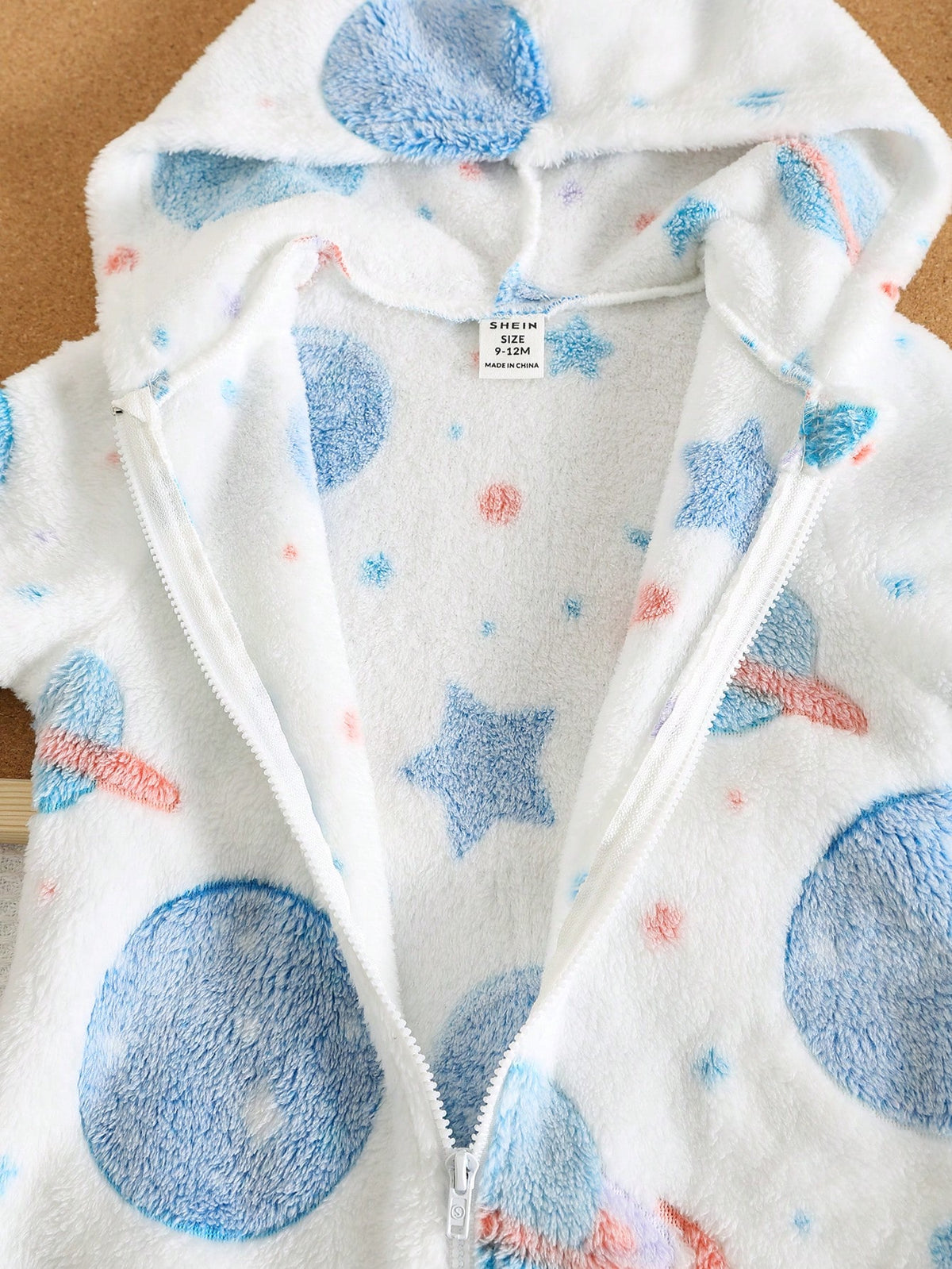 Mameluco blanco para bebe con detalle de capucha y cremallera frontal