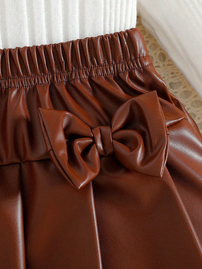 Prenda café falda plisada para bebe con lazos decorativos