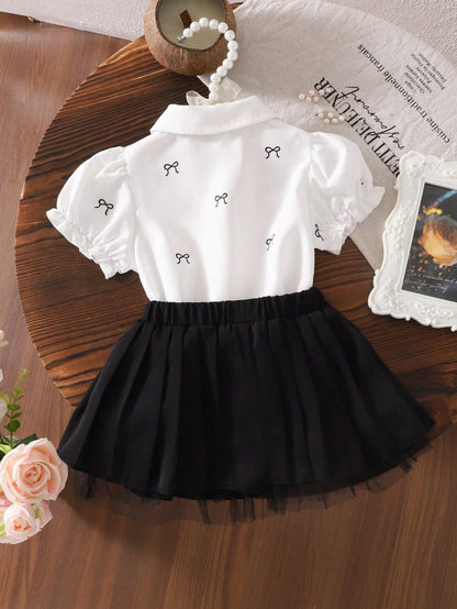 Conjunto blanco y negro con falda plisada y blusa bordada