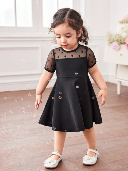 Prenda negro vestido para bebe en uso con acabado elegante