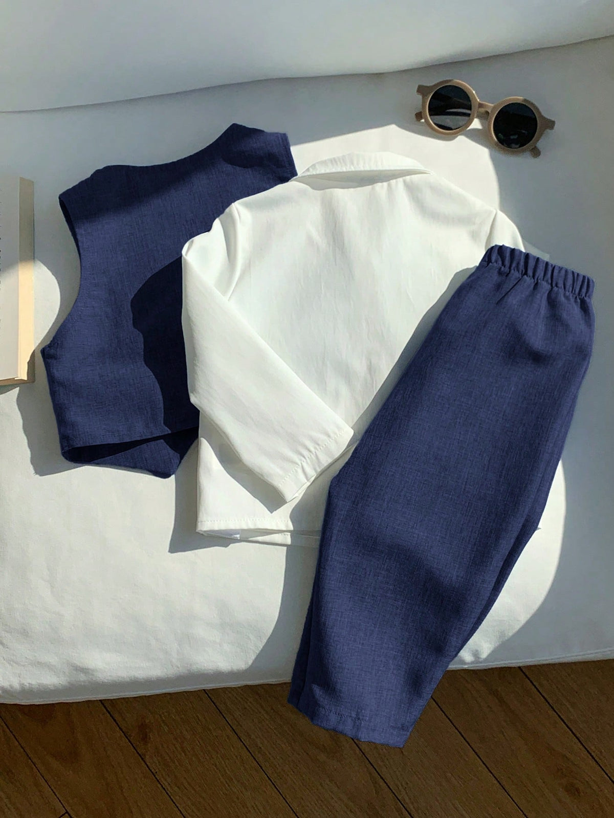 Conjunto azul marino elegante para bebé con camisa blanca, chaleco y pantalón, vista trasera