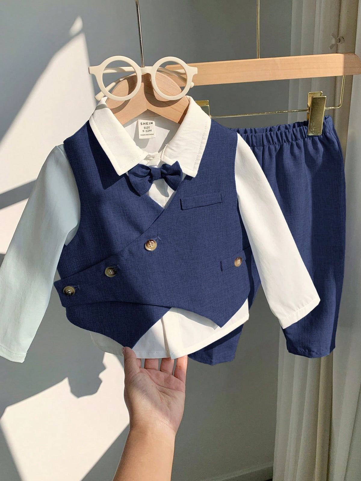 Conjunto azul marino para bebé con detalle de chaleco asimétrico y moño