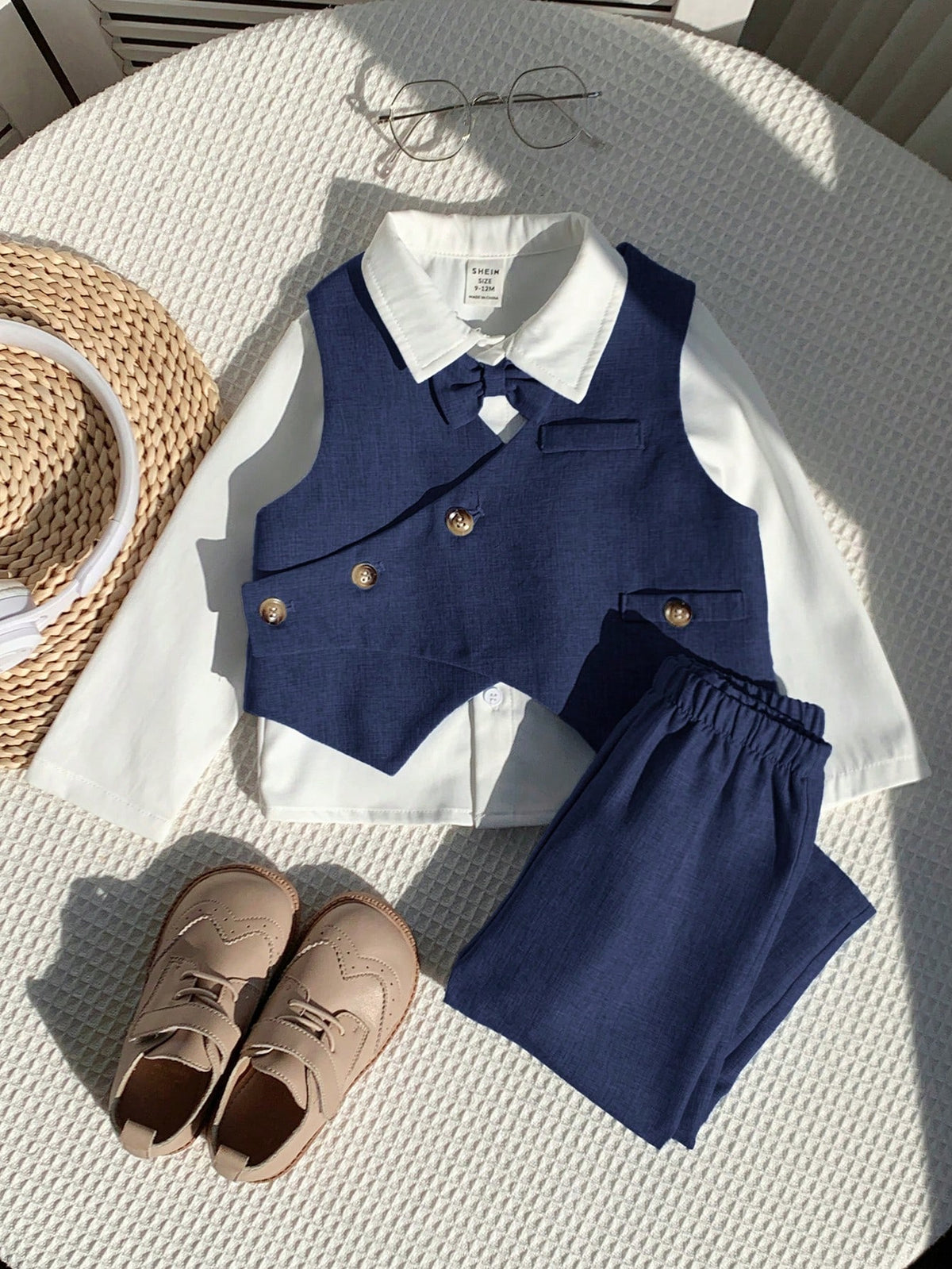 Conjunto azul marino elegante para bebé con pantalón y chaleco, vista frontal sobre superficie blanca