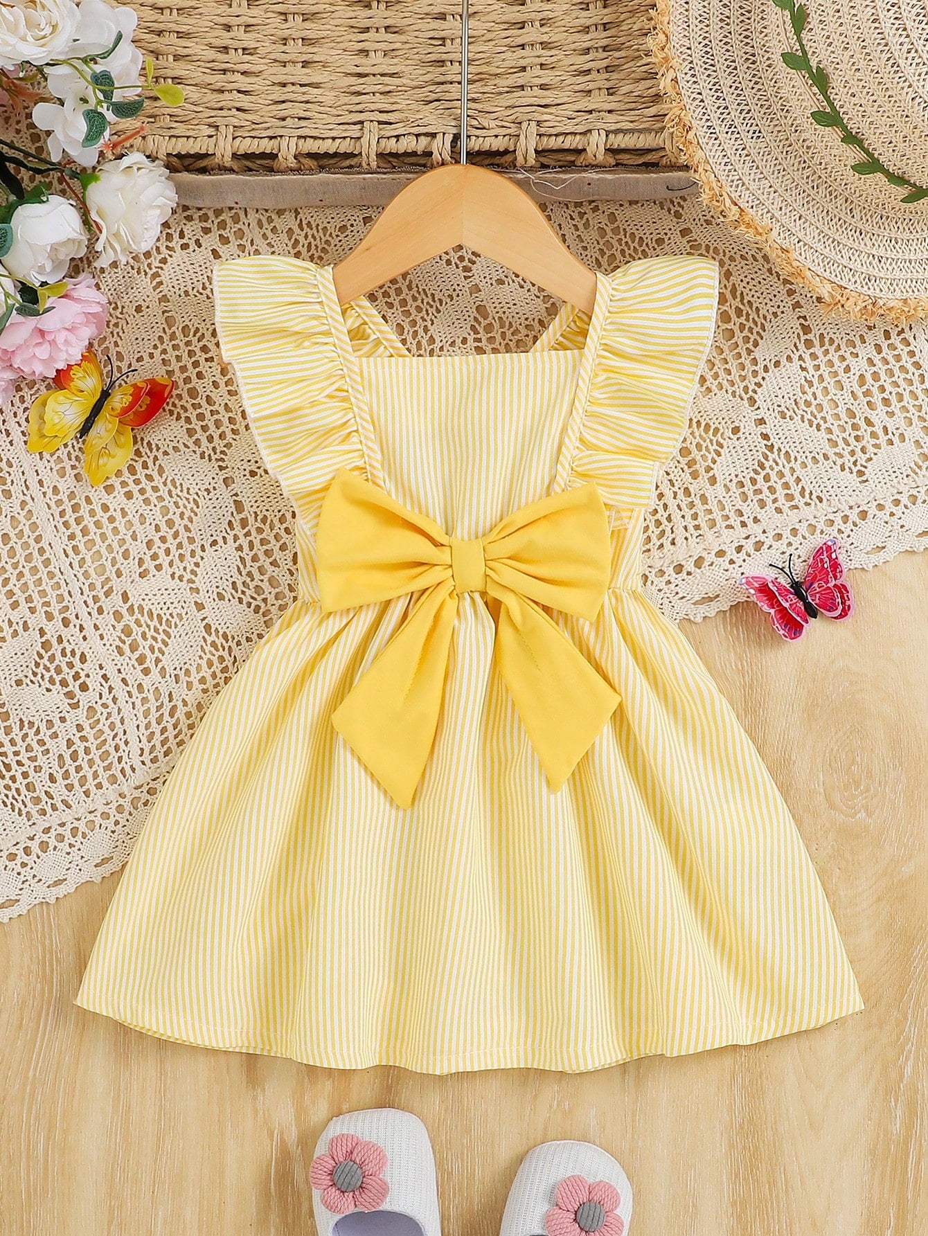 Prenda amarilla vestido para bebe a rayas con lazo grande vista frontal