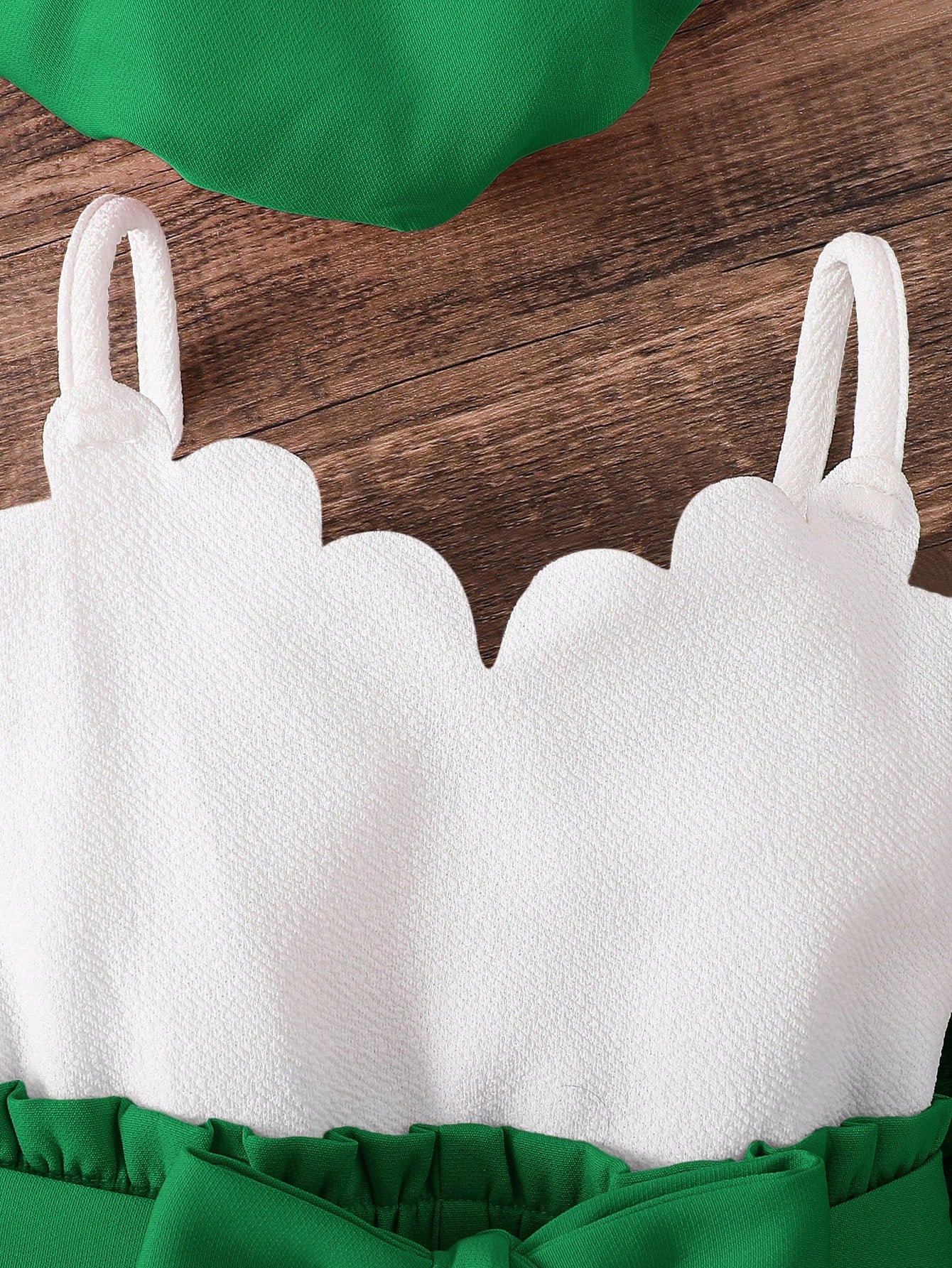 Prenda verde conjunto para bebe con chaleco detalle del top blanco
