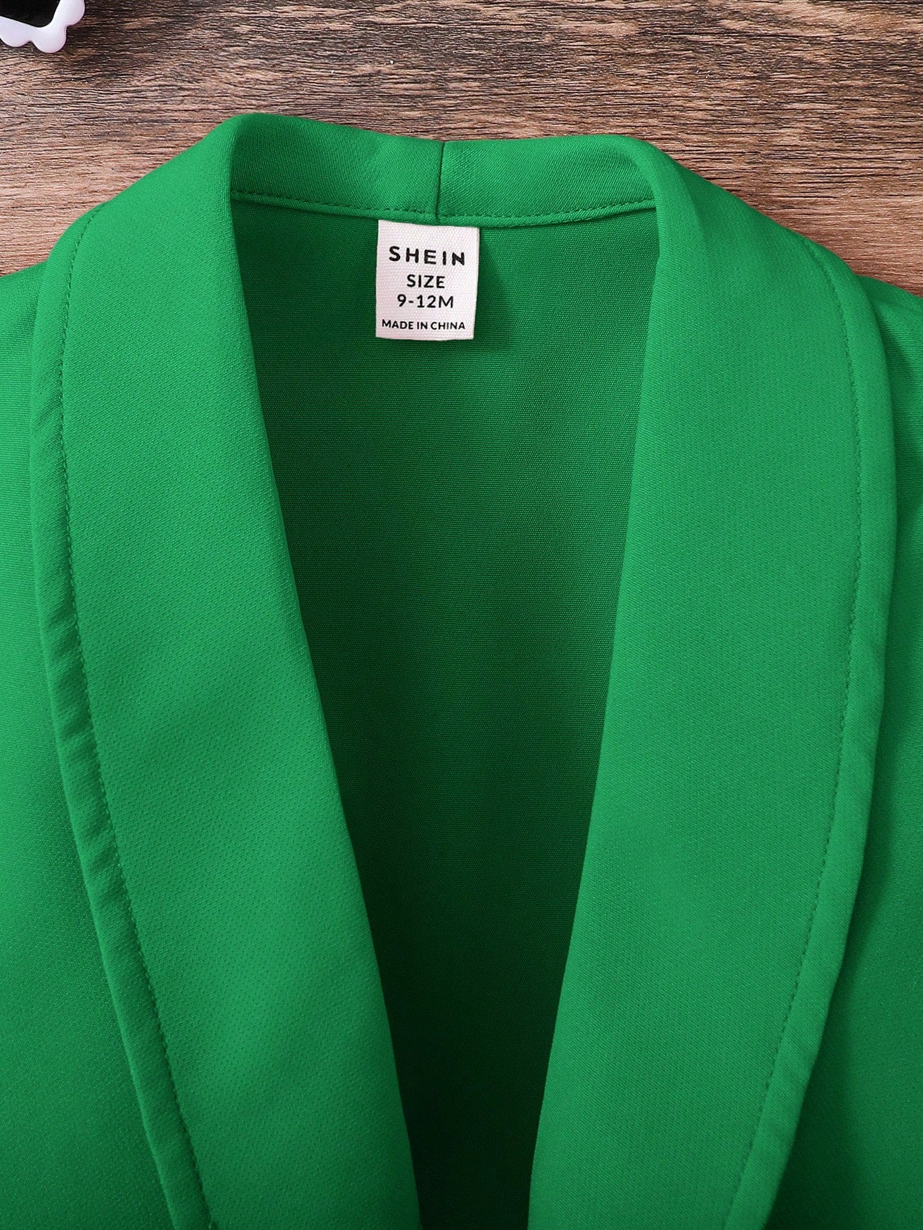 Prenda verde conjunto para bebe con chaleco detalle de etiqueta
