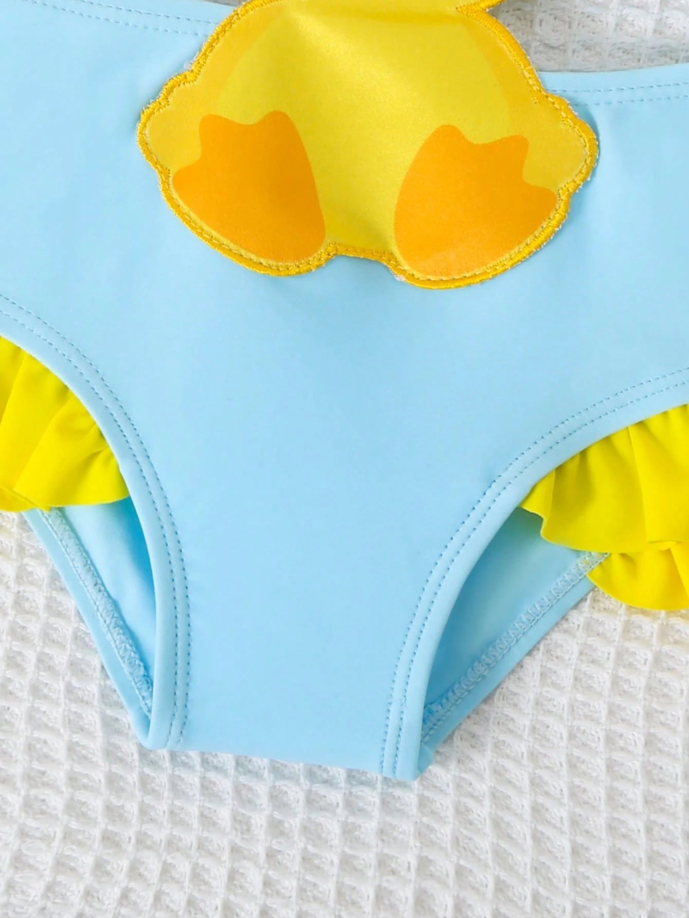 Prenda azul traje de baño para bebe detalle volantes
