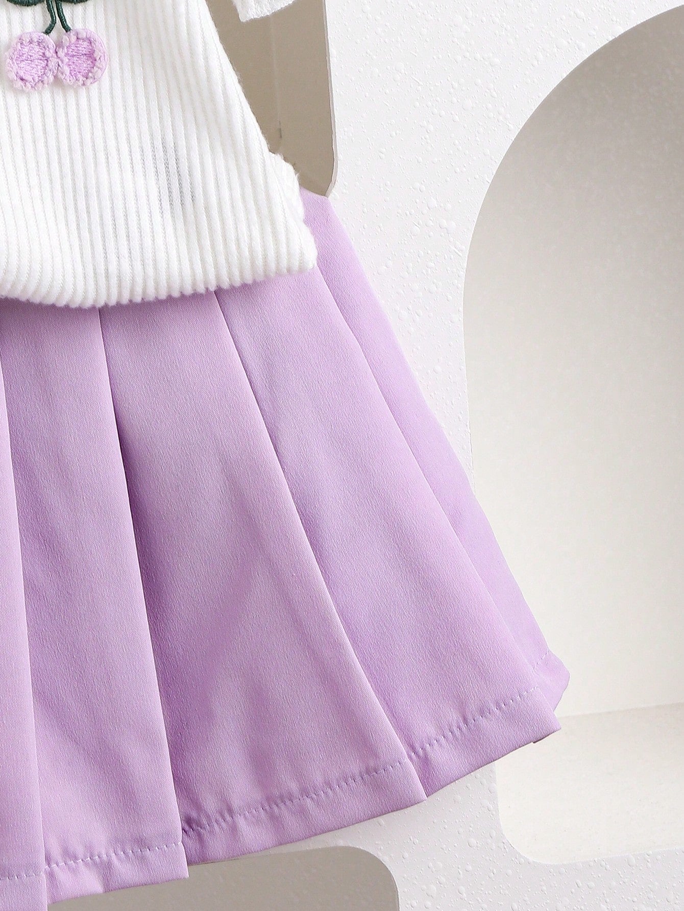 Conjunto morado con blusa bordada y falda plisada