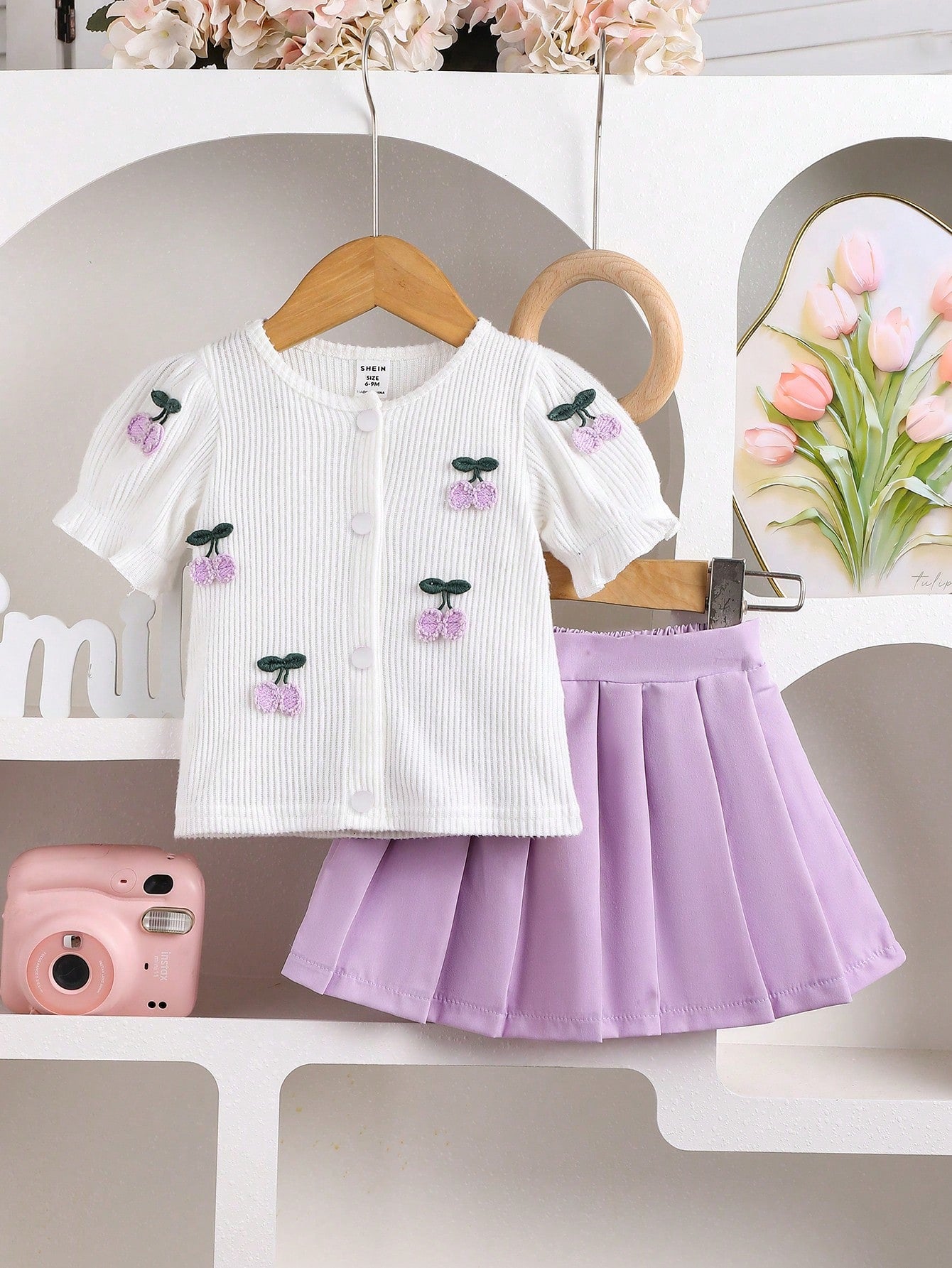 Conjunto morado con blusa bordada y falda plisada