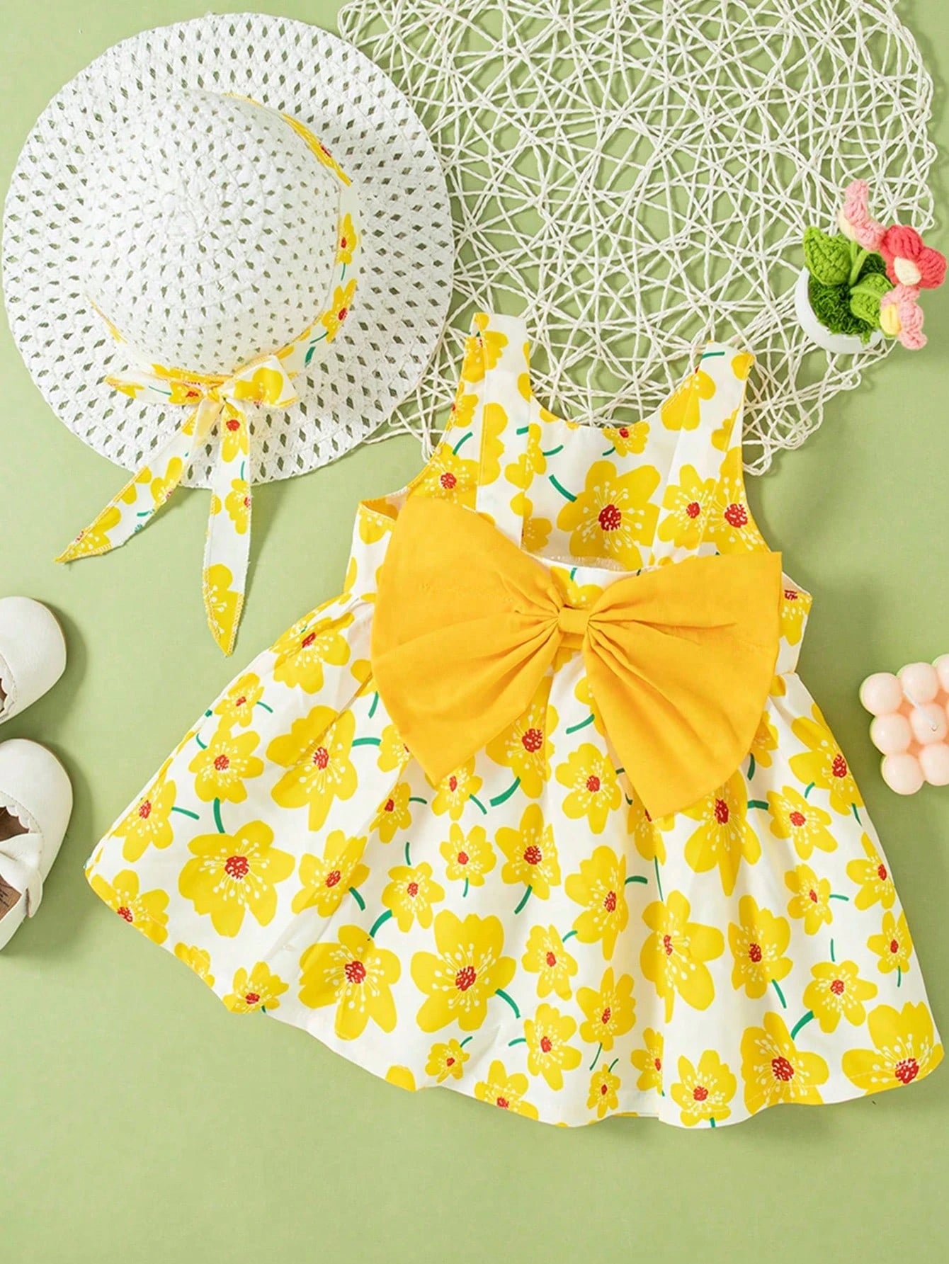Prenda amarilla vestido para bebe con flores y lazo con sombrero vista frontal
