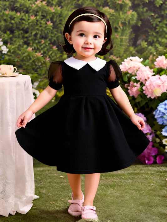 Vestido negro elegante con mangas farol y cuello blanco