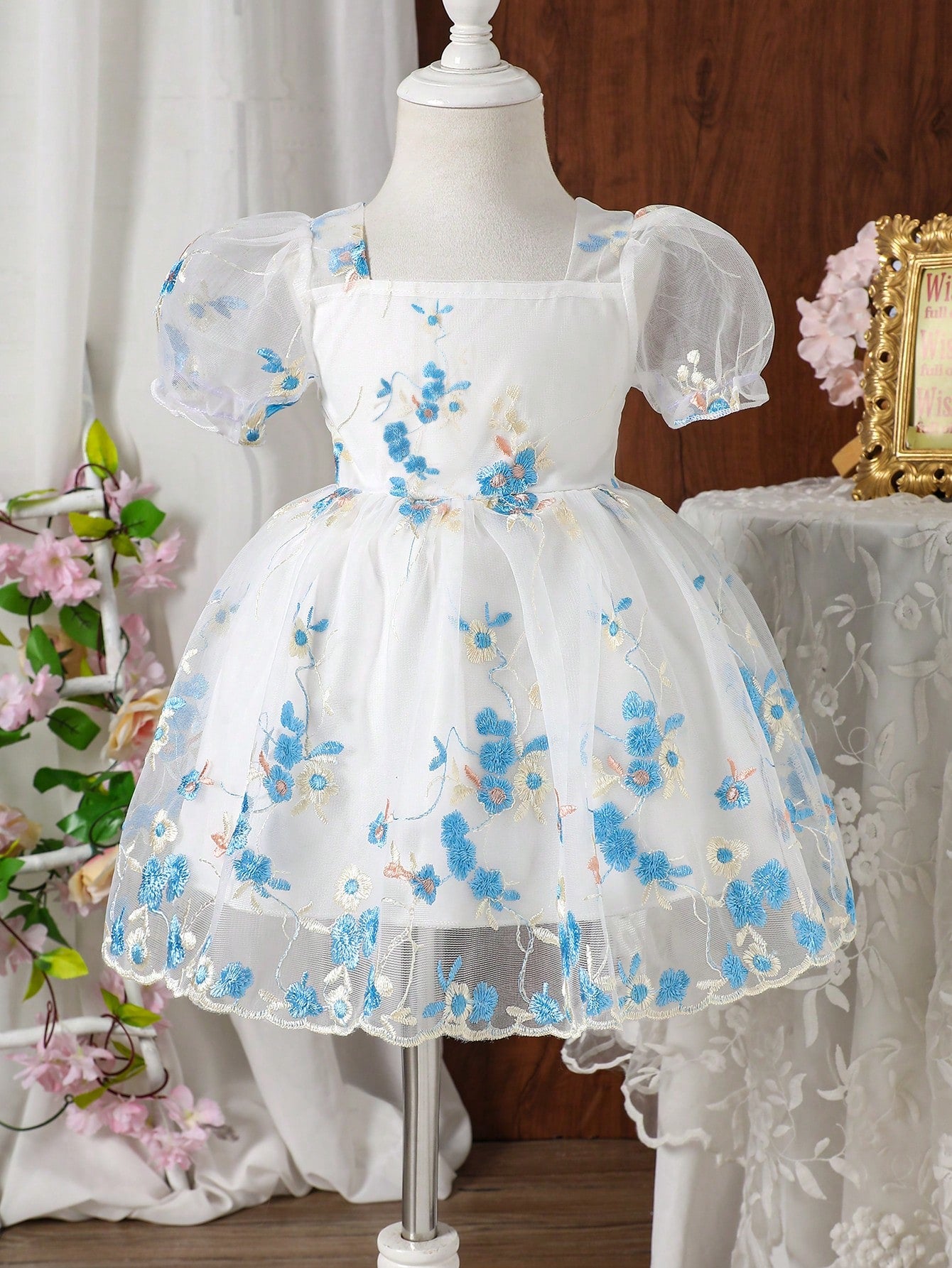 Prenda blanca vestido para bebe con bordado floral azul vista frontal