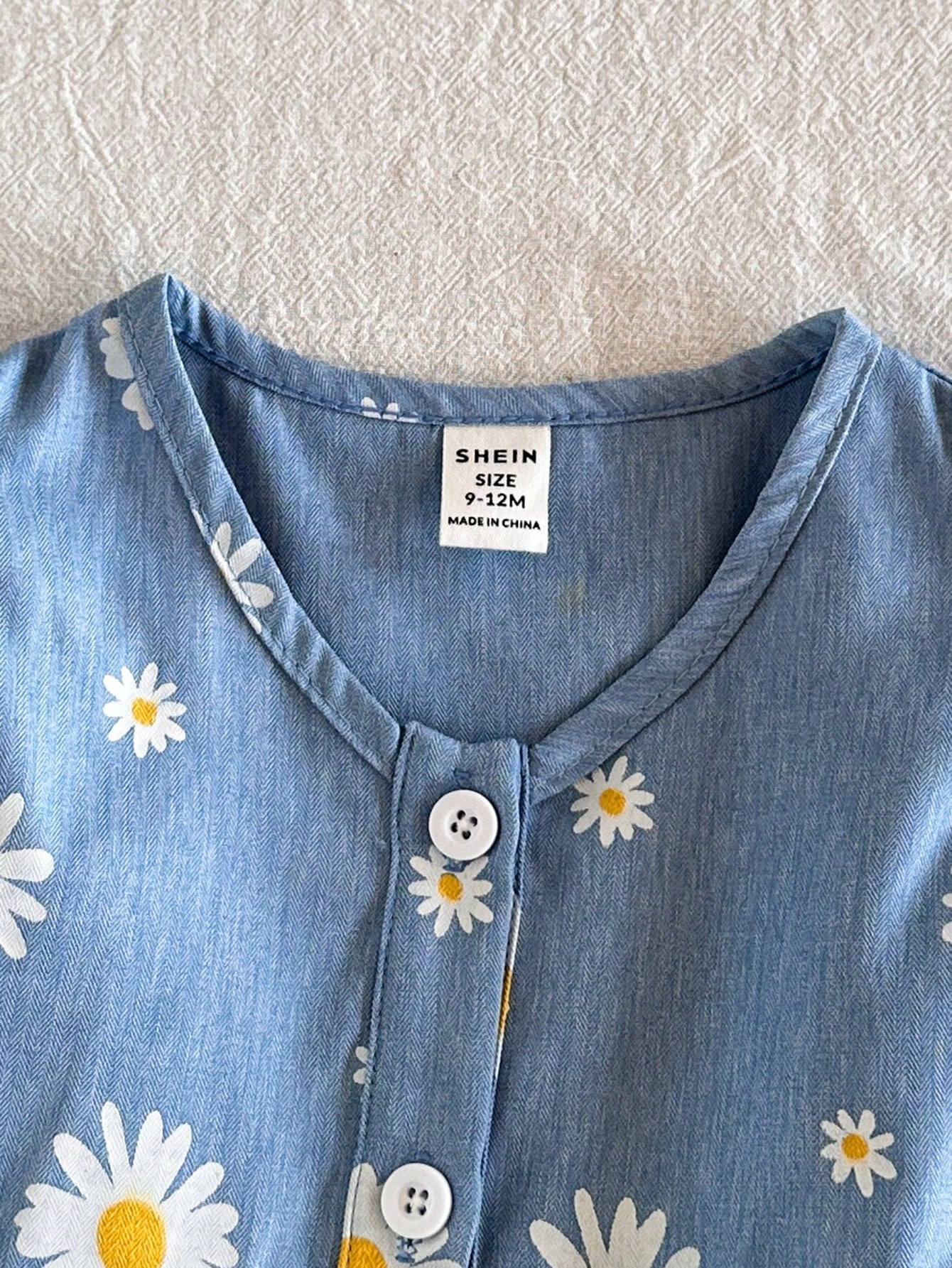 Prenda azul vestido floral para bebe detalle botones frontales