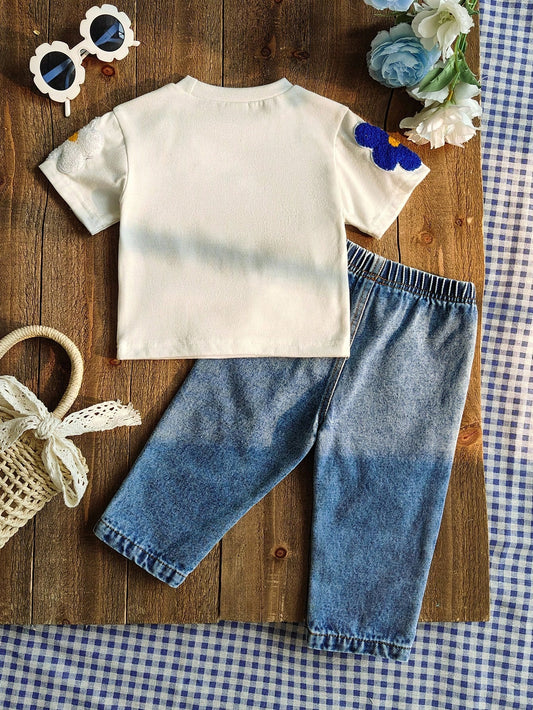 Prenda blanca conjunto para bebe con flores aplicadas y jean azul vista trasera
