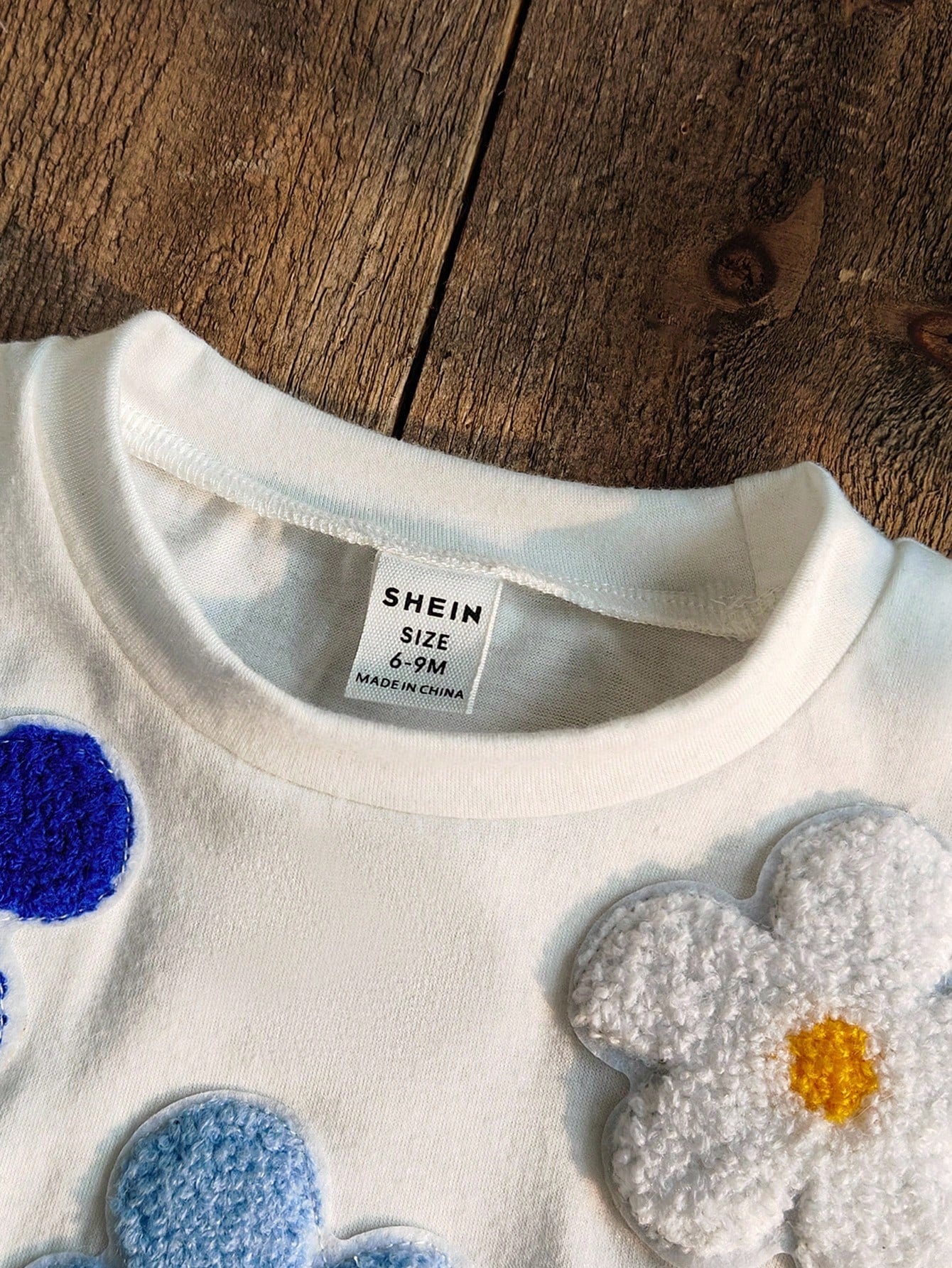 Prenda blanca conjunto para bebe con detalle de flores en relieve
