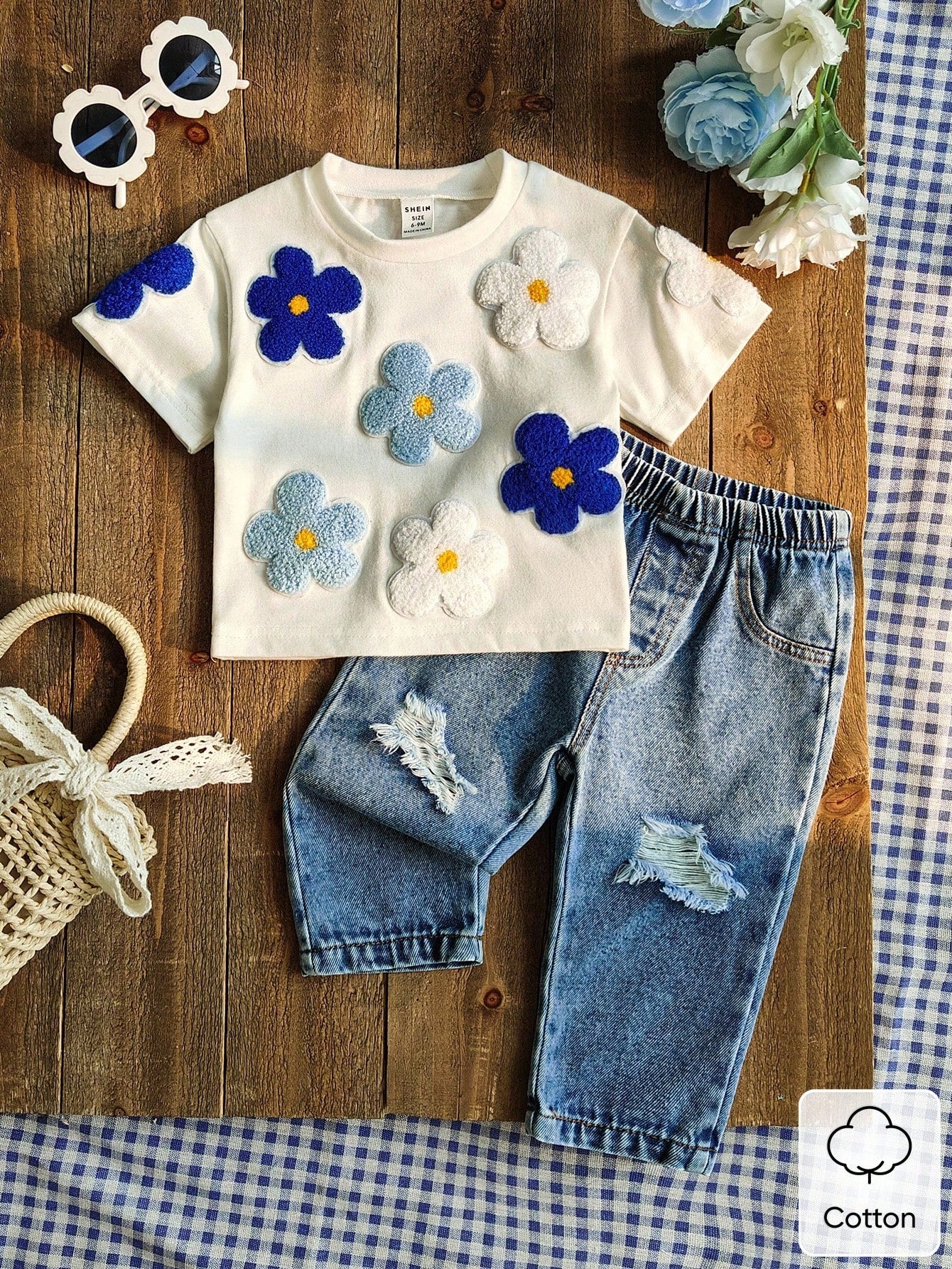 Prenda blanca conjunto para bebe con flores aplicadas y jean azul vista frontal
