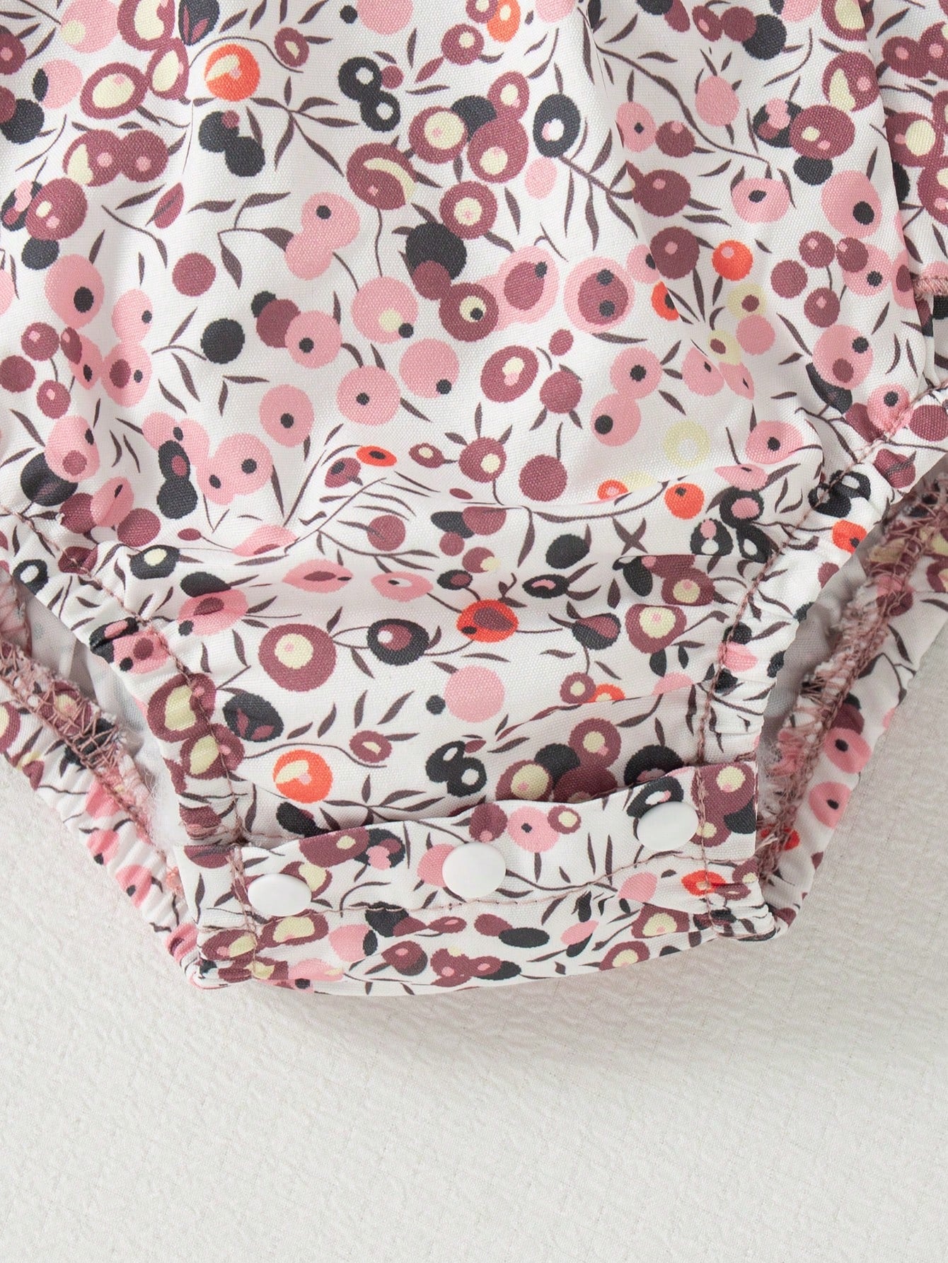 Prenda rosa conjunto para bebe detalle de estampado floral y broches