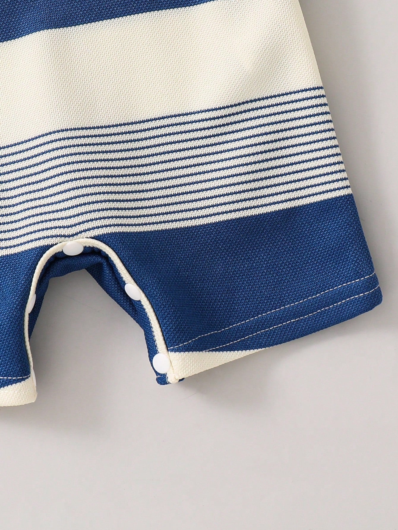Pelele azul a rayas para bebe con detalle de broches inferiores