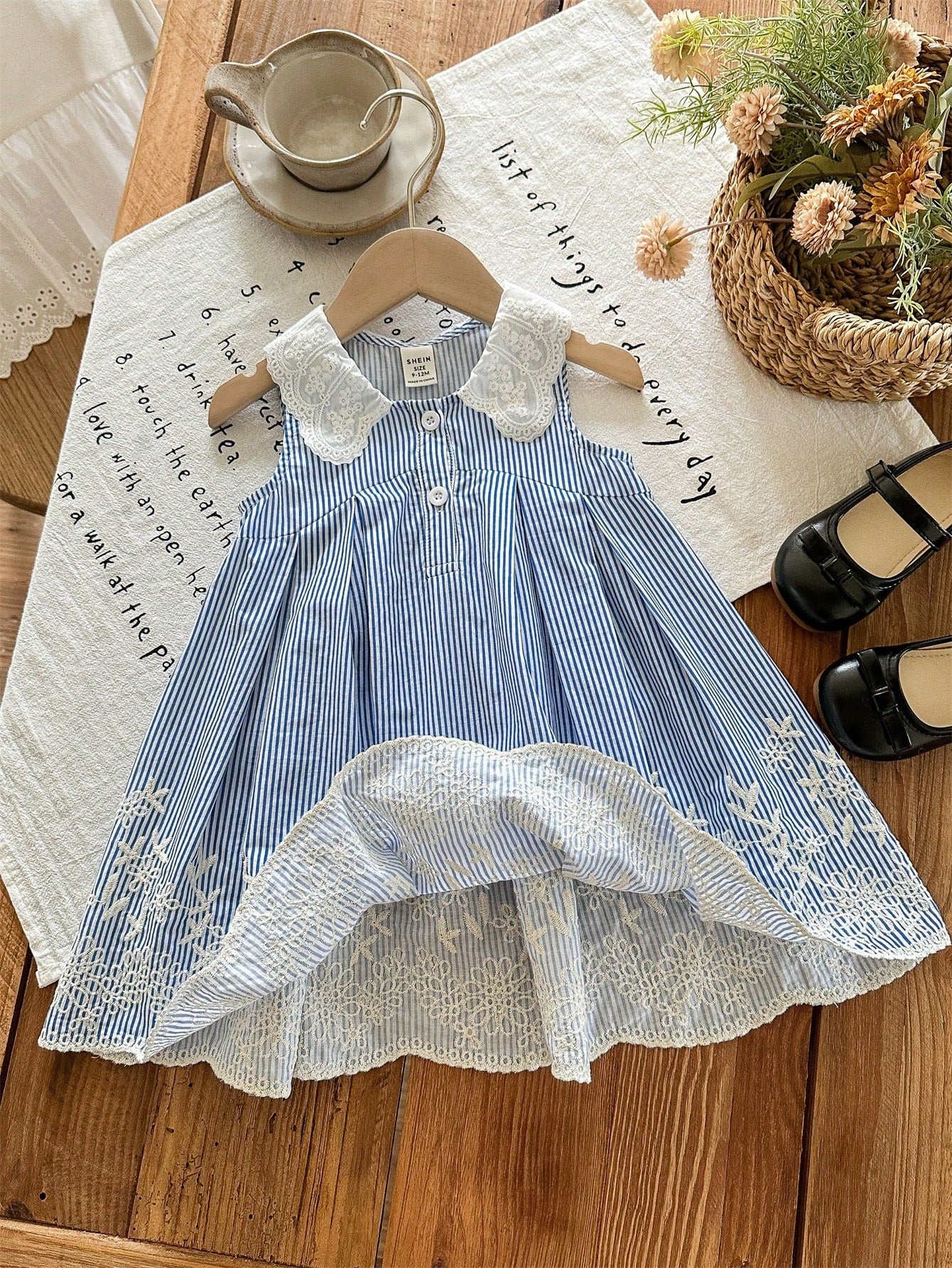 Prenda azul vestido para bebe detalle de bordado floral