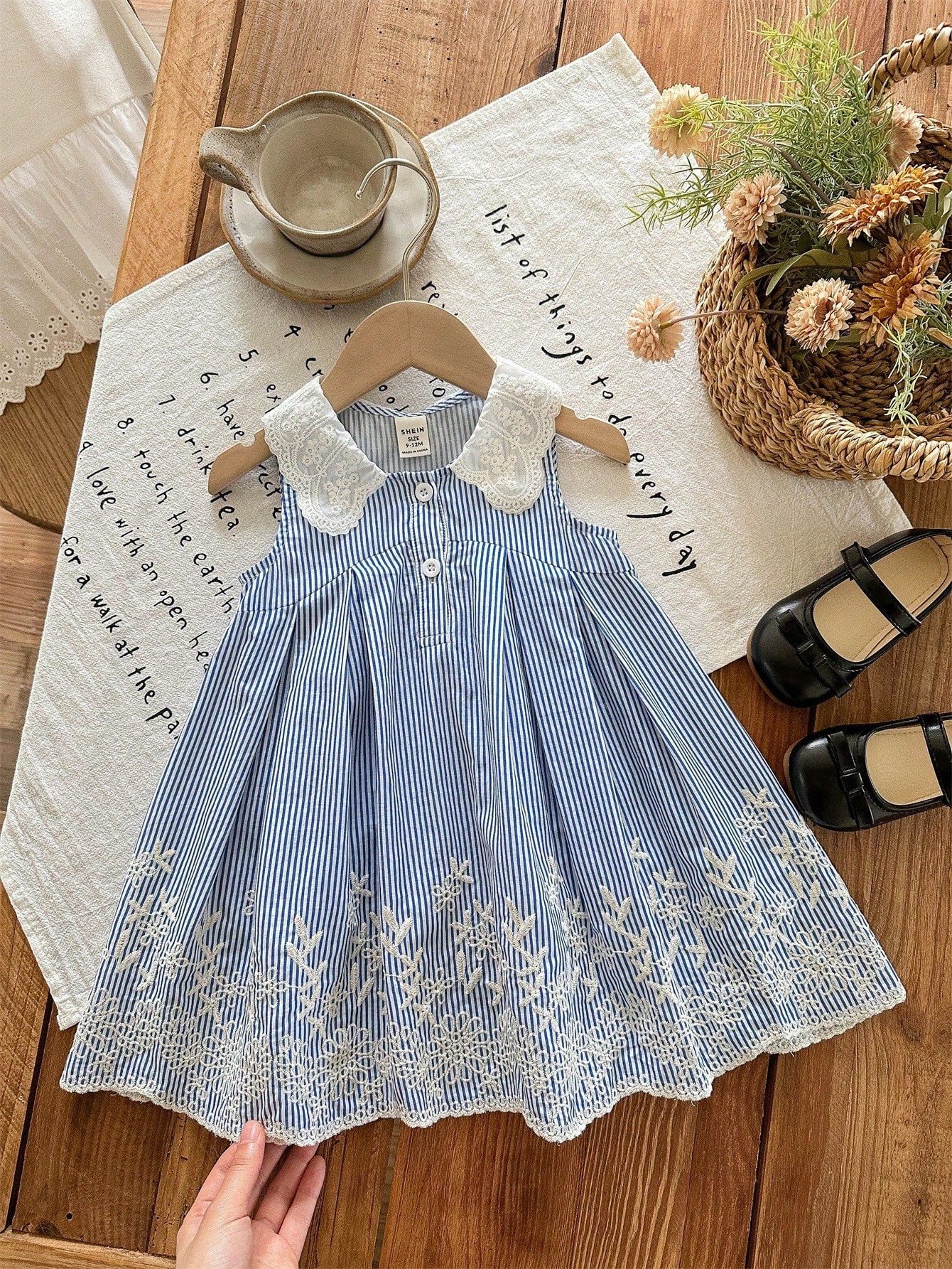 Prenda azul vestido para bebe a rayas con encaje y bordado vista frontal
