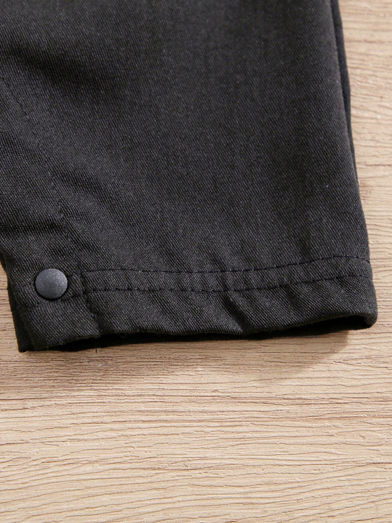 Prenda negro enterizo elegante para bebe con detalle de botones y acabado