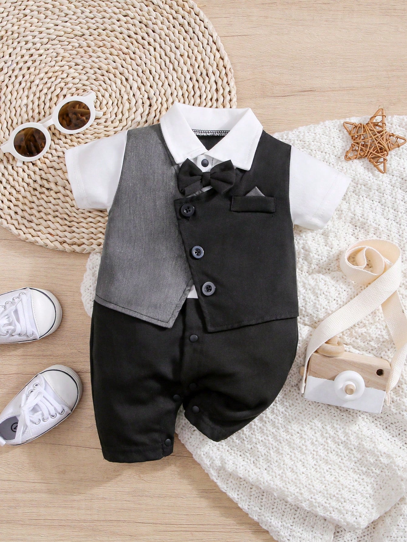 Prenda negro enterizo elegante para bebe con chaleco y corbatín vista frontal
