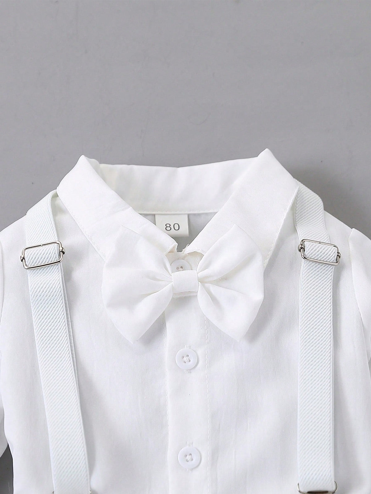 Prenda blanca conjunto para bebe detalle de cuello camisero, moño y tirantes ajustables