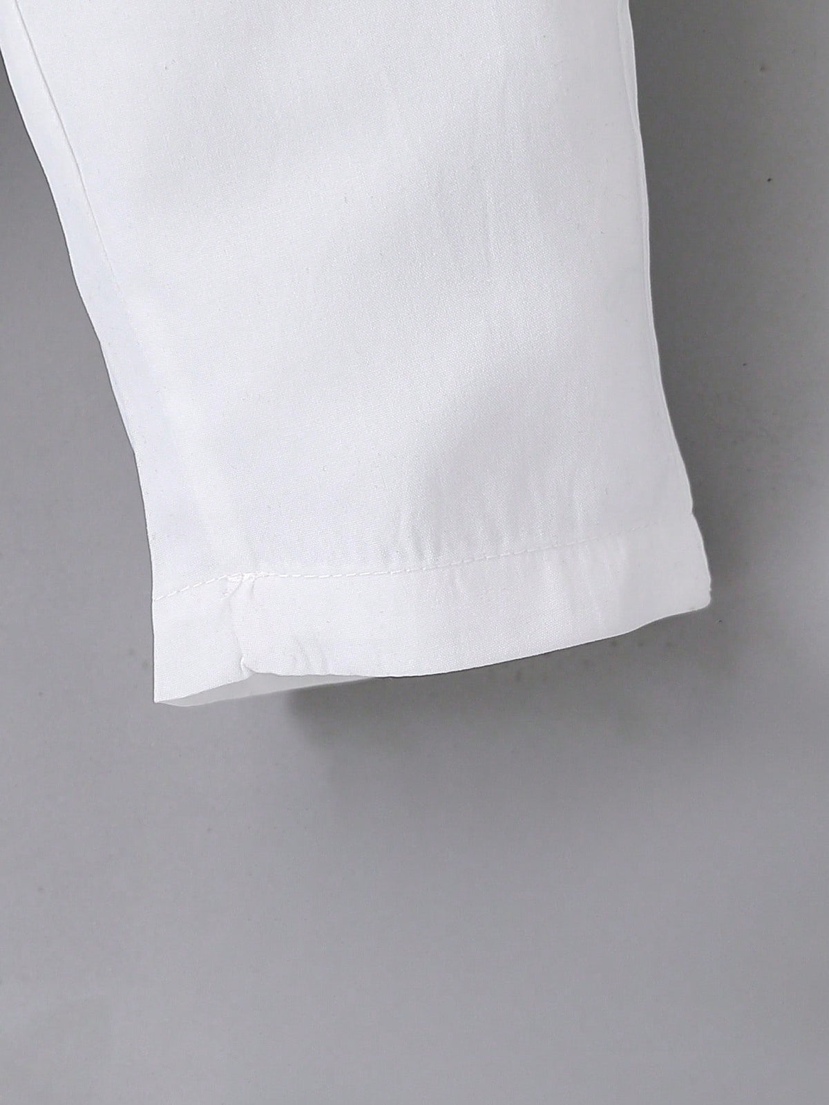 Prenda blanca conjunto para bebe detalle de acabado del pantalón largo