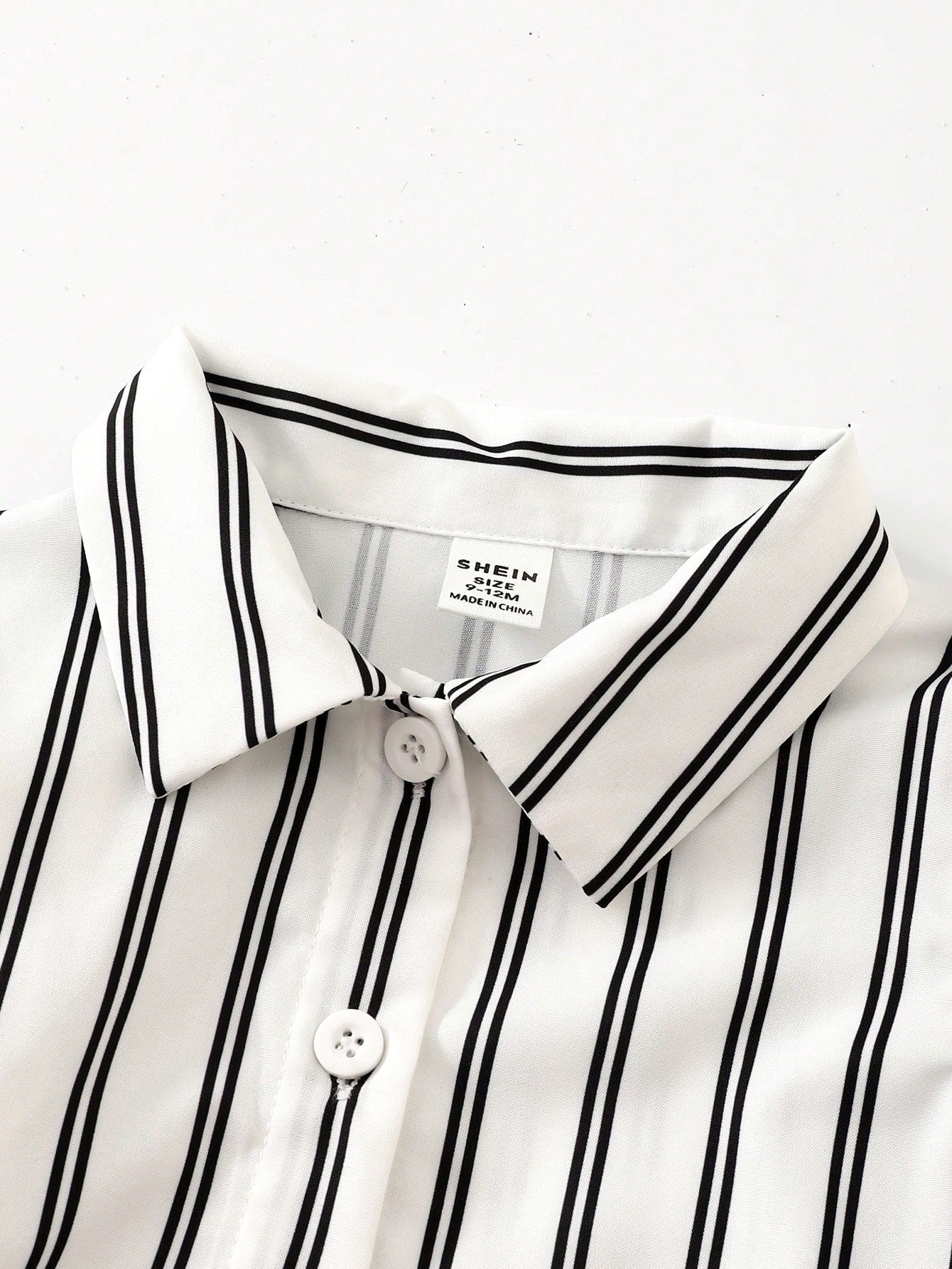 Prenda blanca camisa para bebe a rayas con cuello camisero detalle del acabado