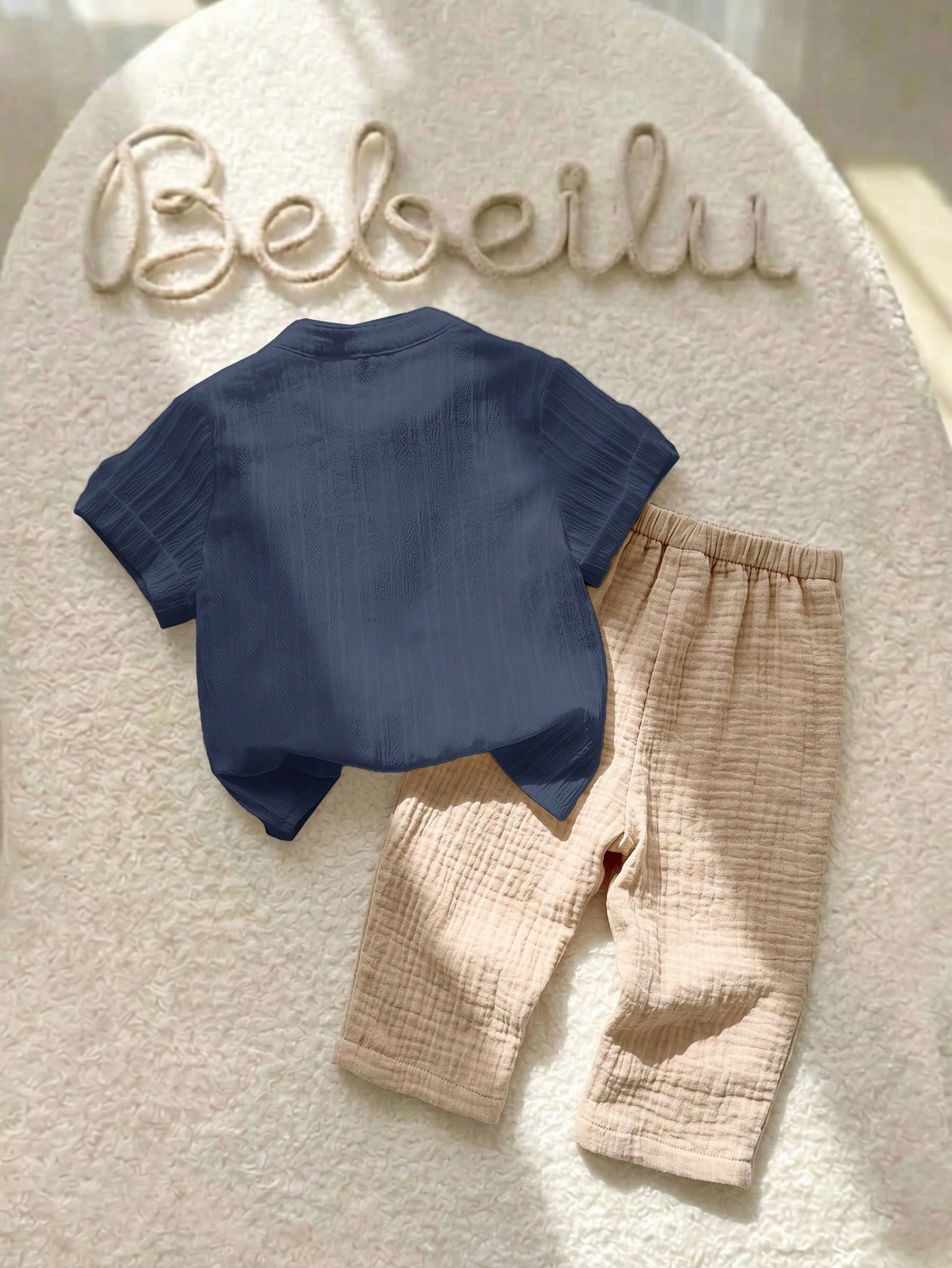 Prenda azul y beige conjunto para bebe de dos piezas vista trasera