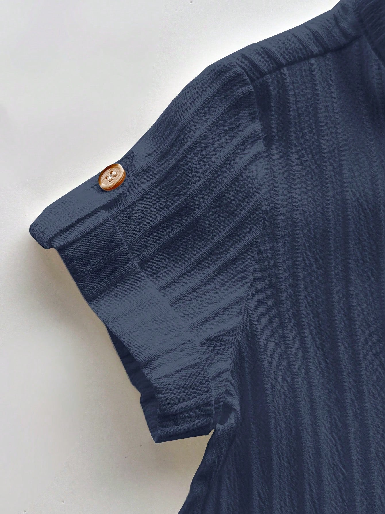Prenda azul camisa para bebe con manga corta y botón detalle del acabado
