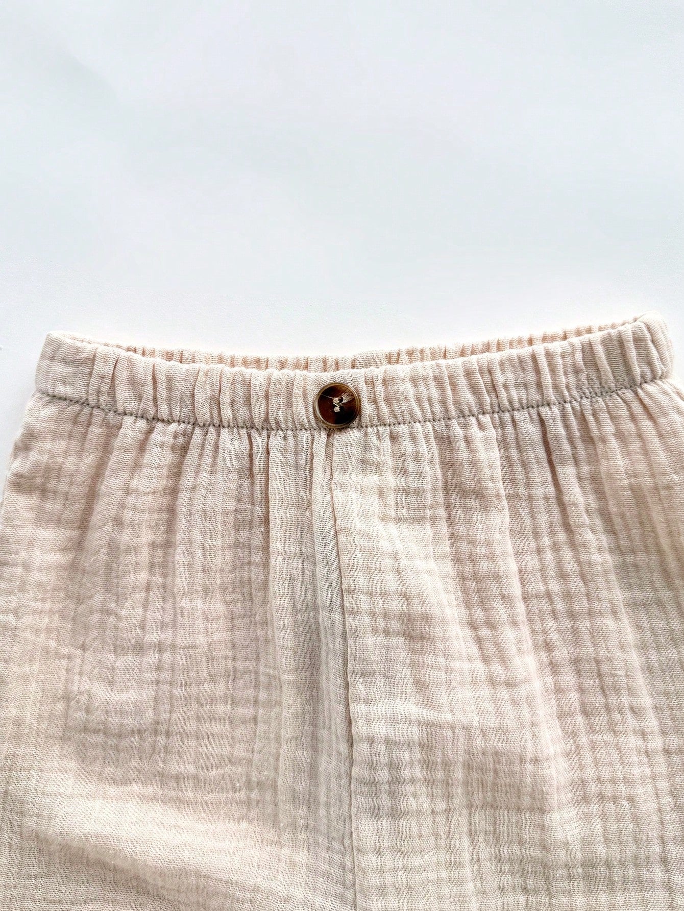 Prenda beige pantalón para bebe con cintura elástica detalle del acabado