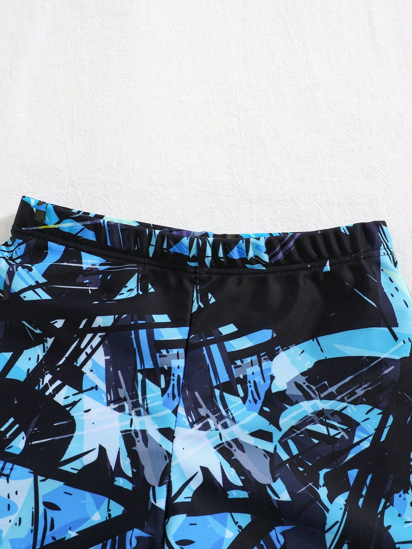 Prenda azul shorts traje de baño para bebe detalle estampado abstracto