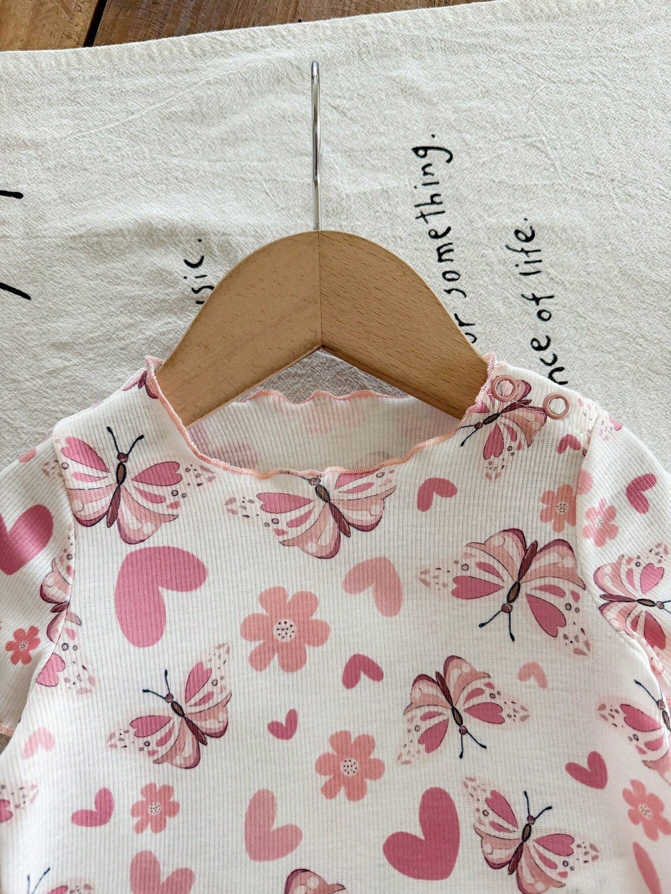 Prenda blanca blusa para bebe con mariposas rosadas detalle del cuello