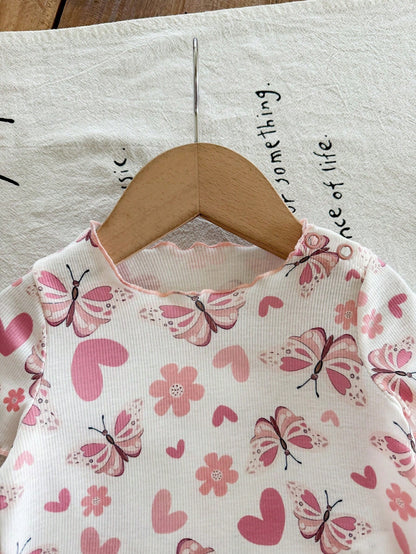 Prenda blanca blusa para bebe con mariposas rosadas detalle del cuello
