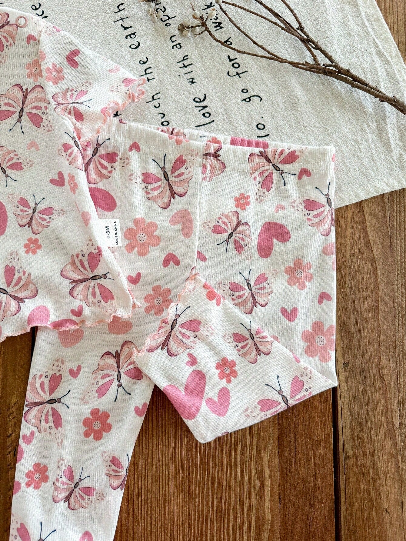 Prenda blanca pantalón para bebe con mariposas rosadas detalle del acabado