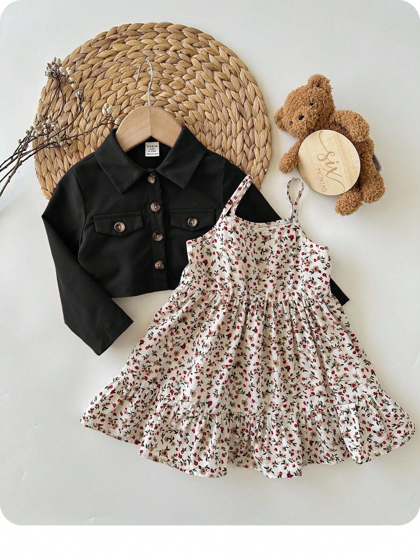 Prenda negra conjunto para bebe con vestido floral y chaqueta vista frontal