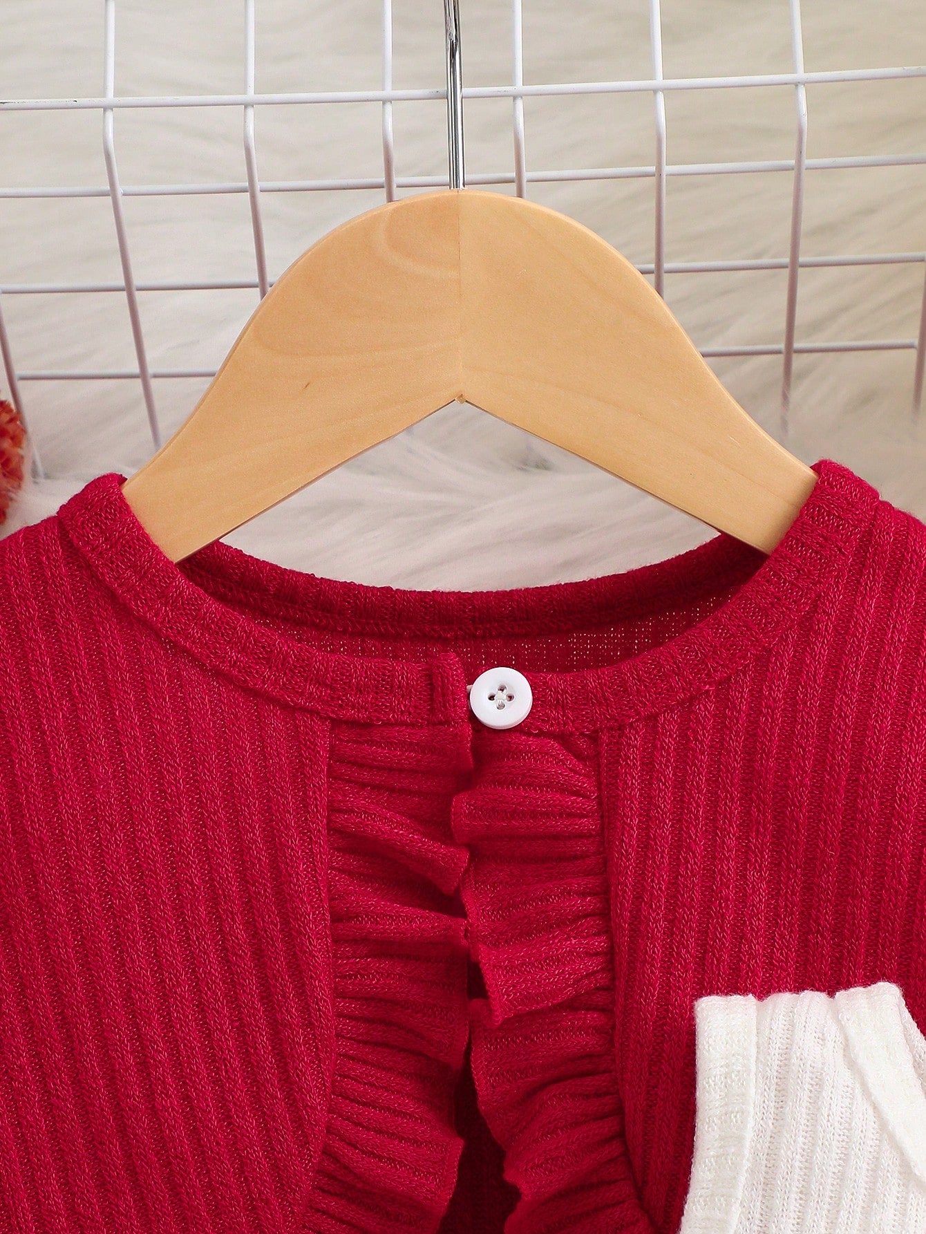 Prenda roja cárdigan para bebe con volante frontal detalle del acabado