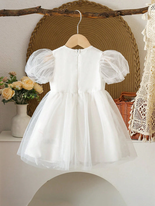 Prenda blanca vestido para bebe con encaje y tul vista trasera
