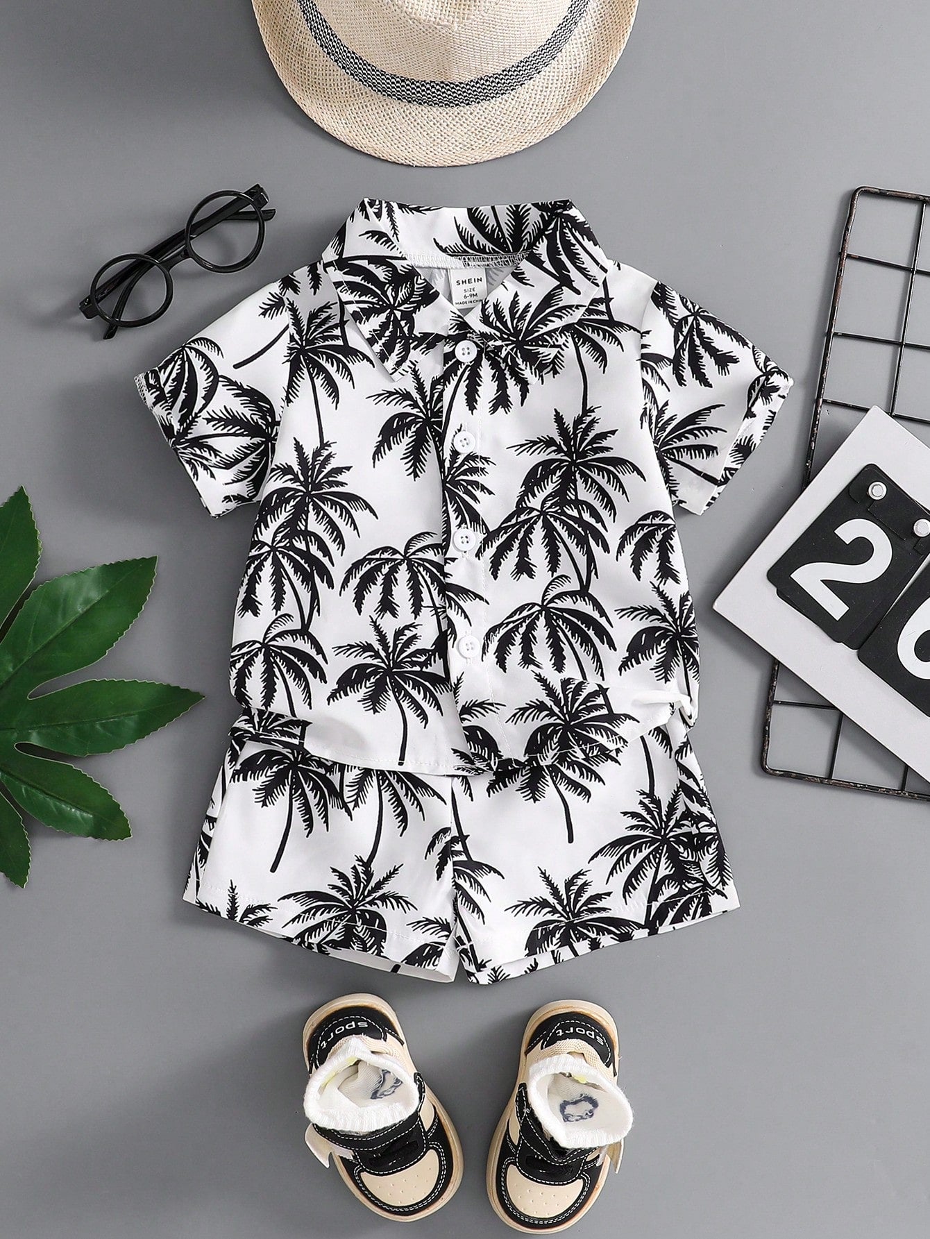 Prenda blanco negro conjunto tropical para bebe con estampado de palmeras vista frontal