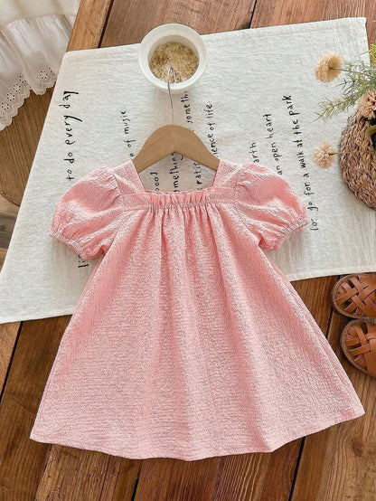 Prenda rosa pálido vestido para bebe con manga abullonada vista posterior