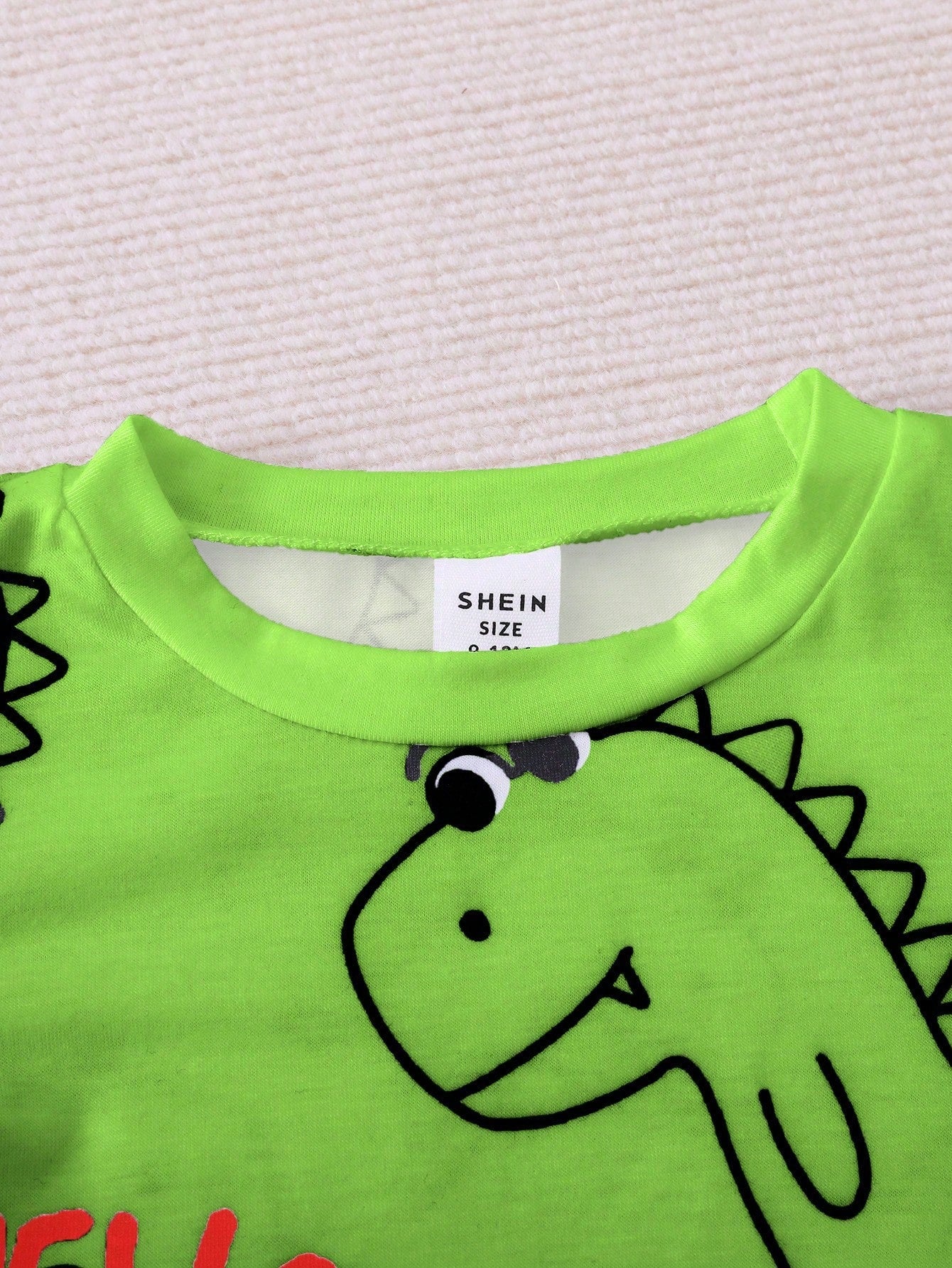 Prenda verde camiseta para bebe con cuello redondo detalle superior
