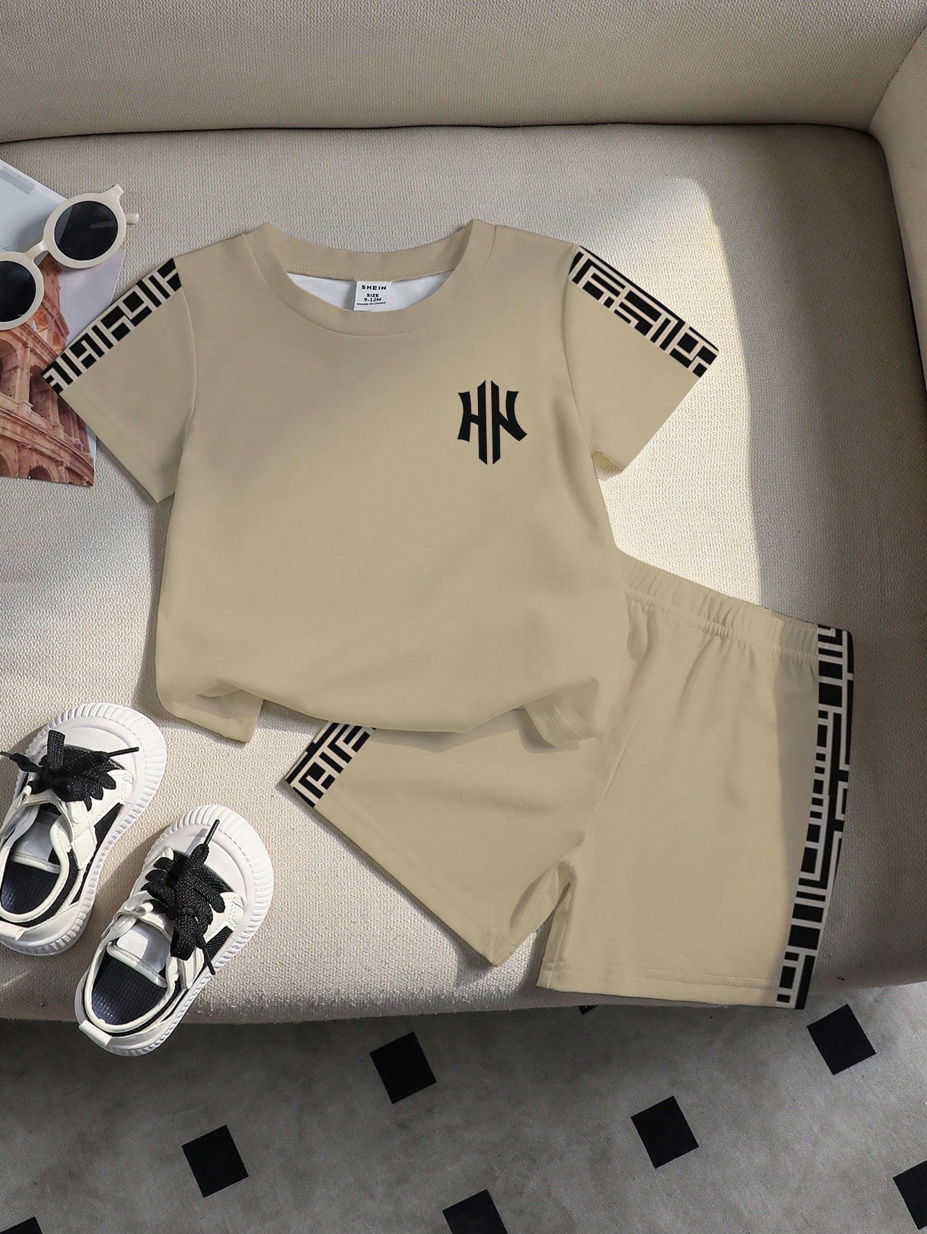 Prenda beige conjunto para bebe con detalles geometricos vista frontal
